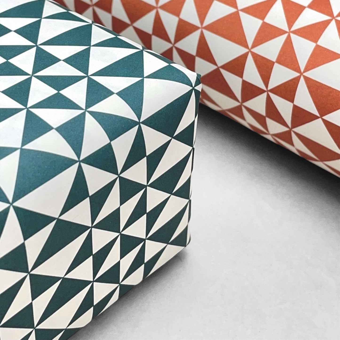 wrapping paper with an abstract triangle pattern in deep teal and white by Ola Studio