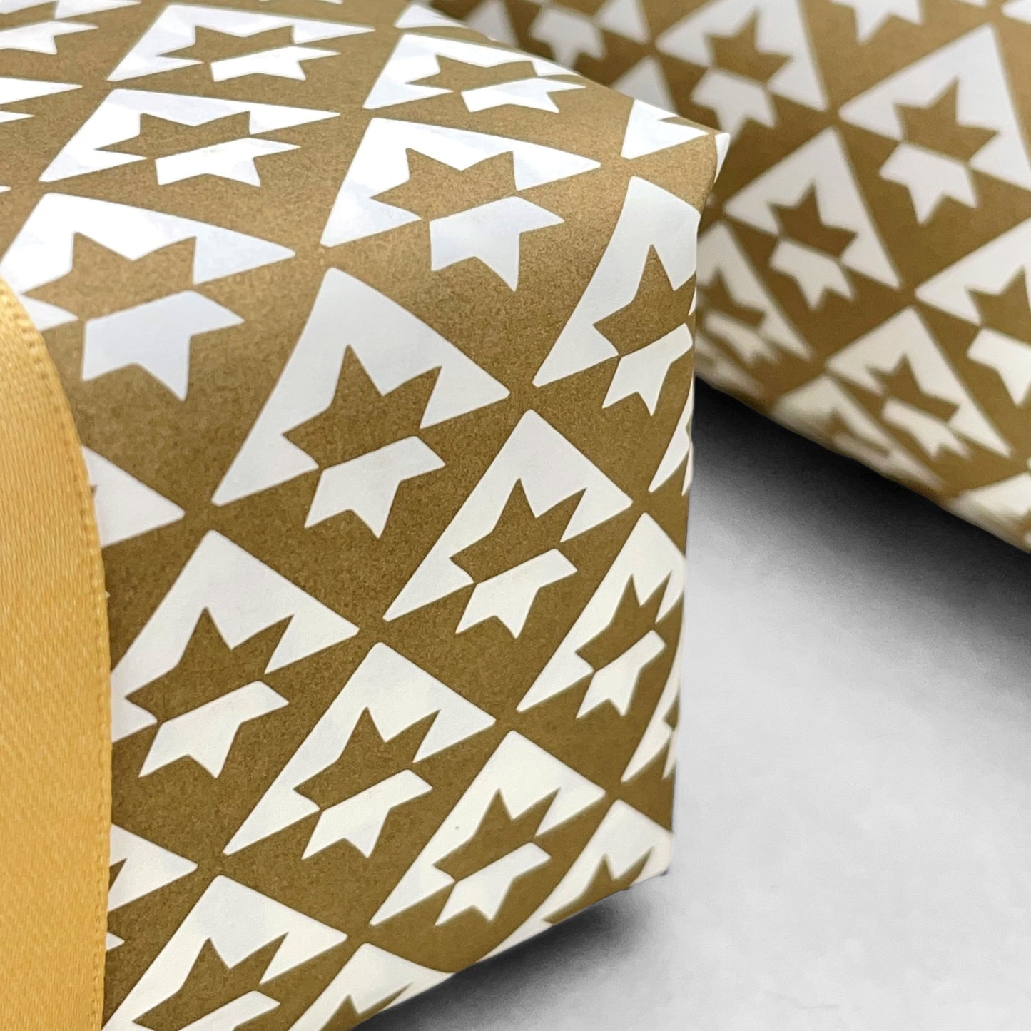 wrapping paper with an abstract star pattern in gold and white by Ola Studio