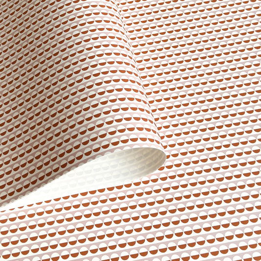 wrapping paper with an abstract circle pattern in orange and pale pink by Ola Studio