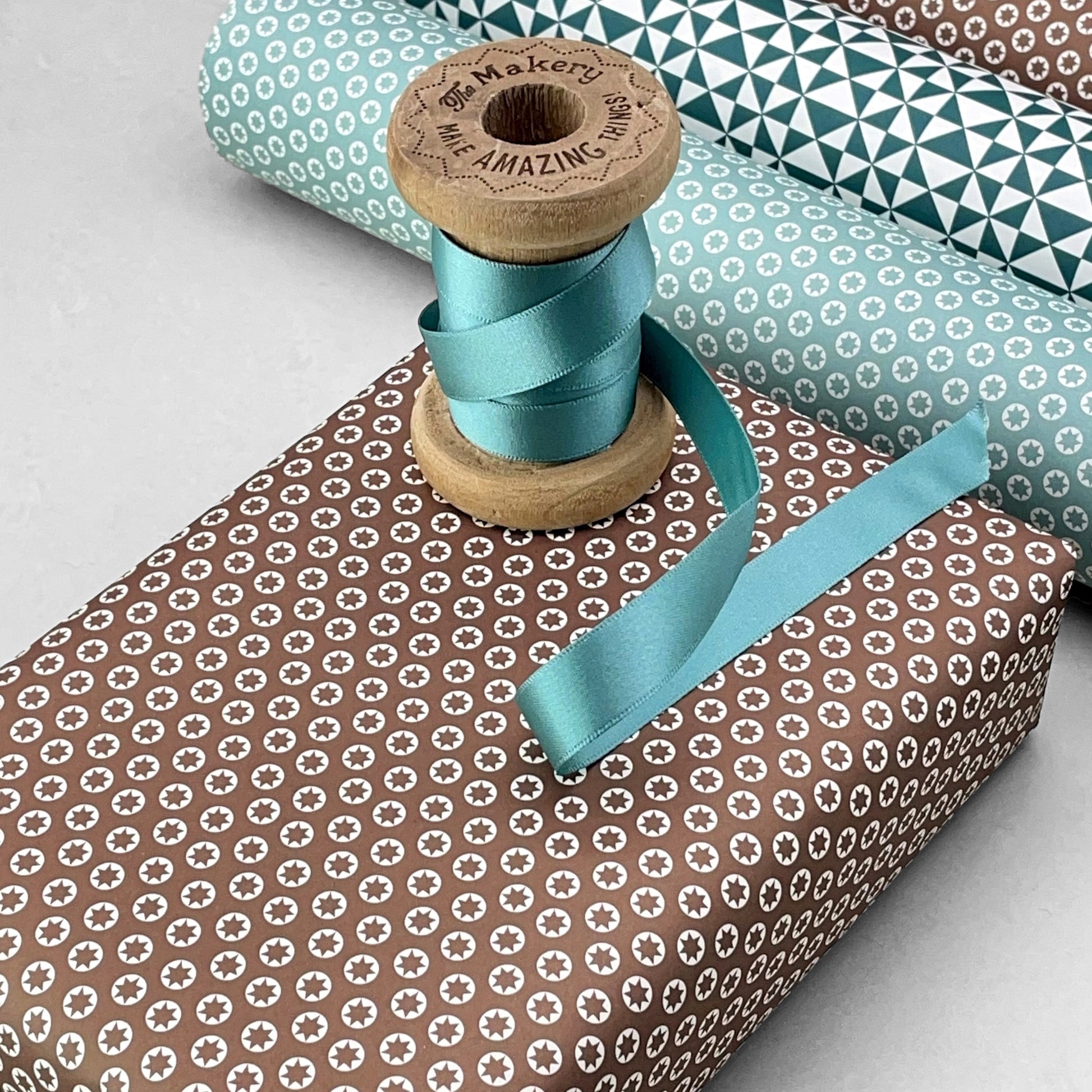 wrapping paper with an abstract tiny stars pattern in chestnut brown and white by Ola Studio