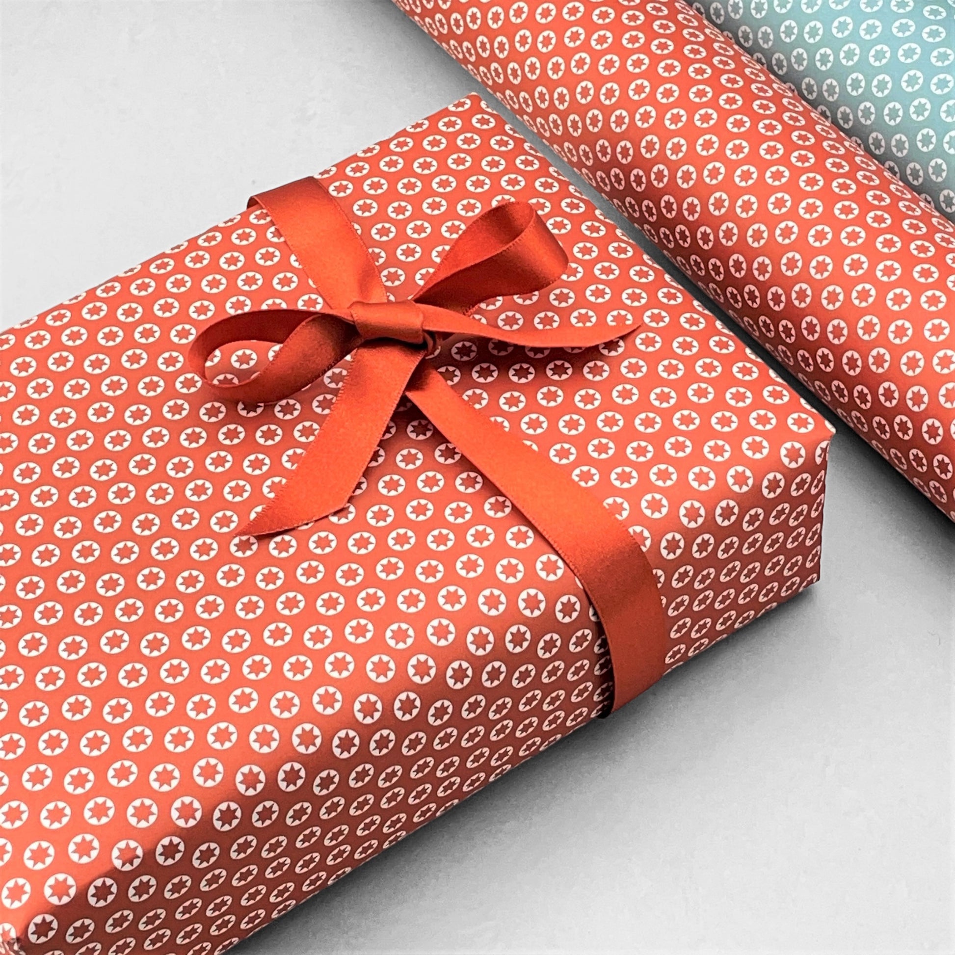 wrapping paper with an abstract tiny stars pattern in red and white by Ola Studio