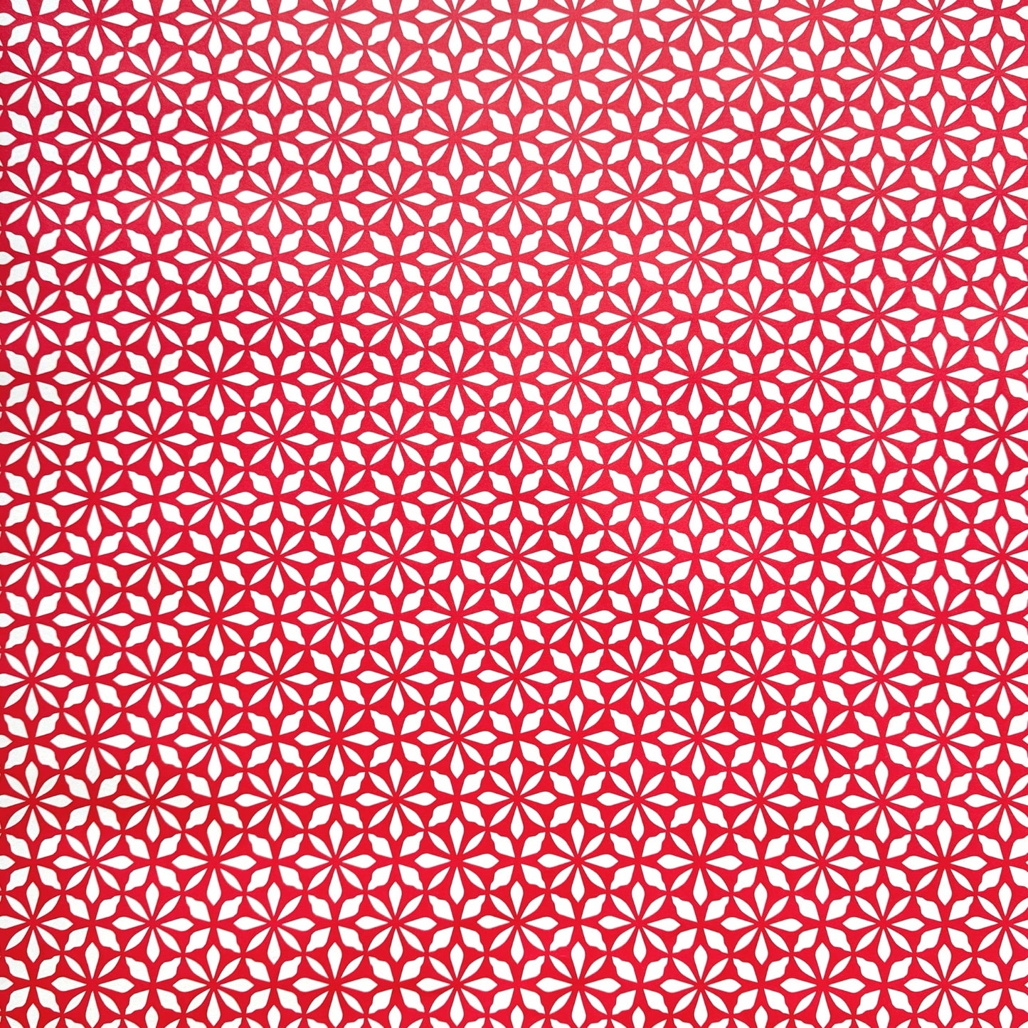 wrapping paper by Otto Editions with a cut-out flower design in white on a magenta pink background.