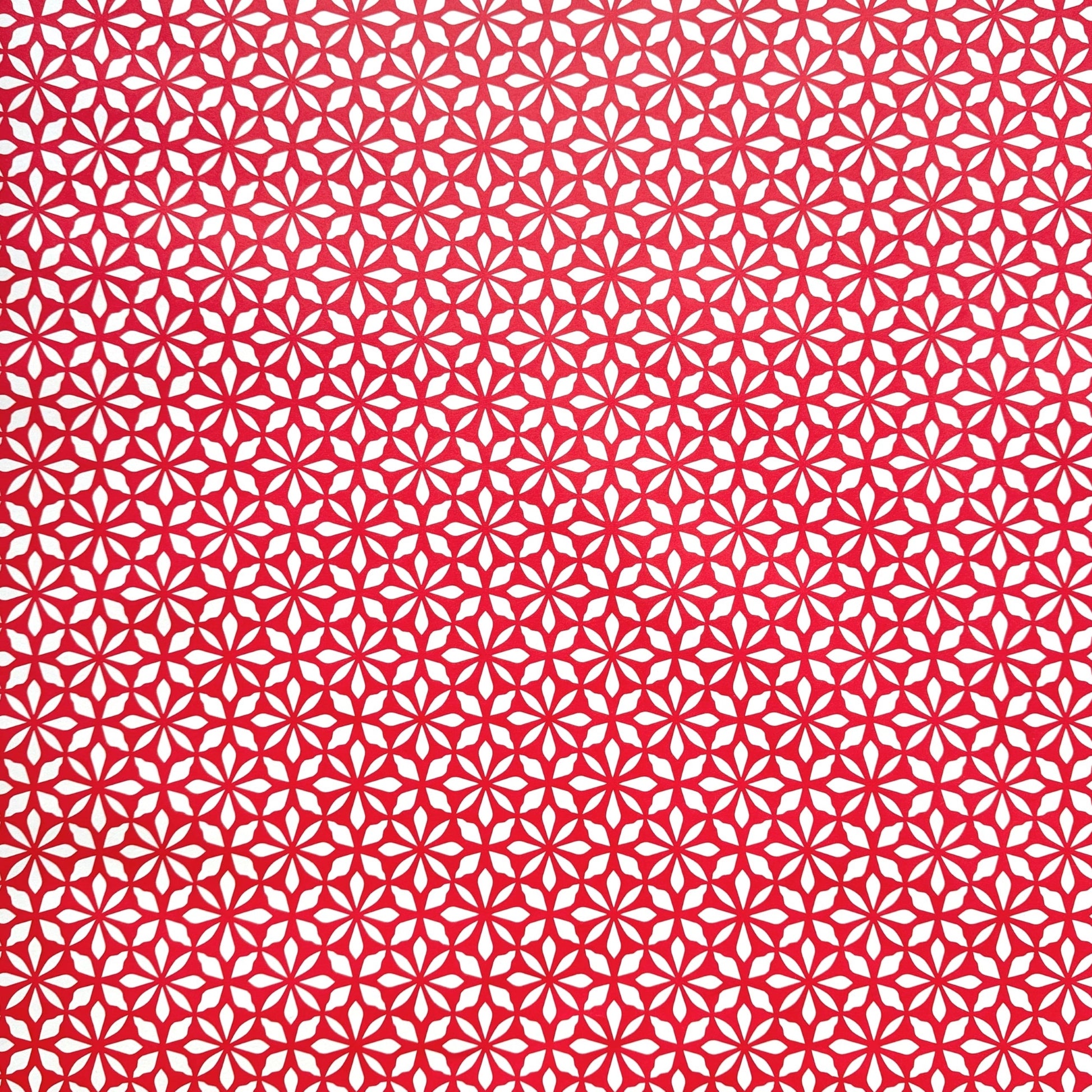 wrapping paper by Otto Editions with a cut-out flower design in white on a magenta pink background.