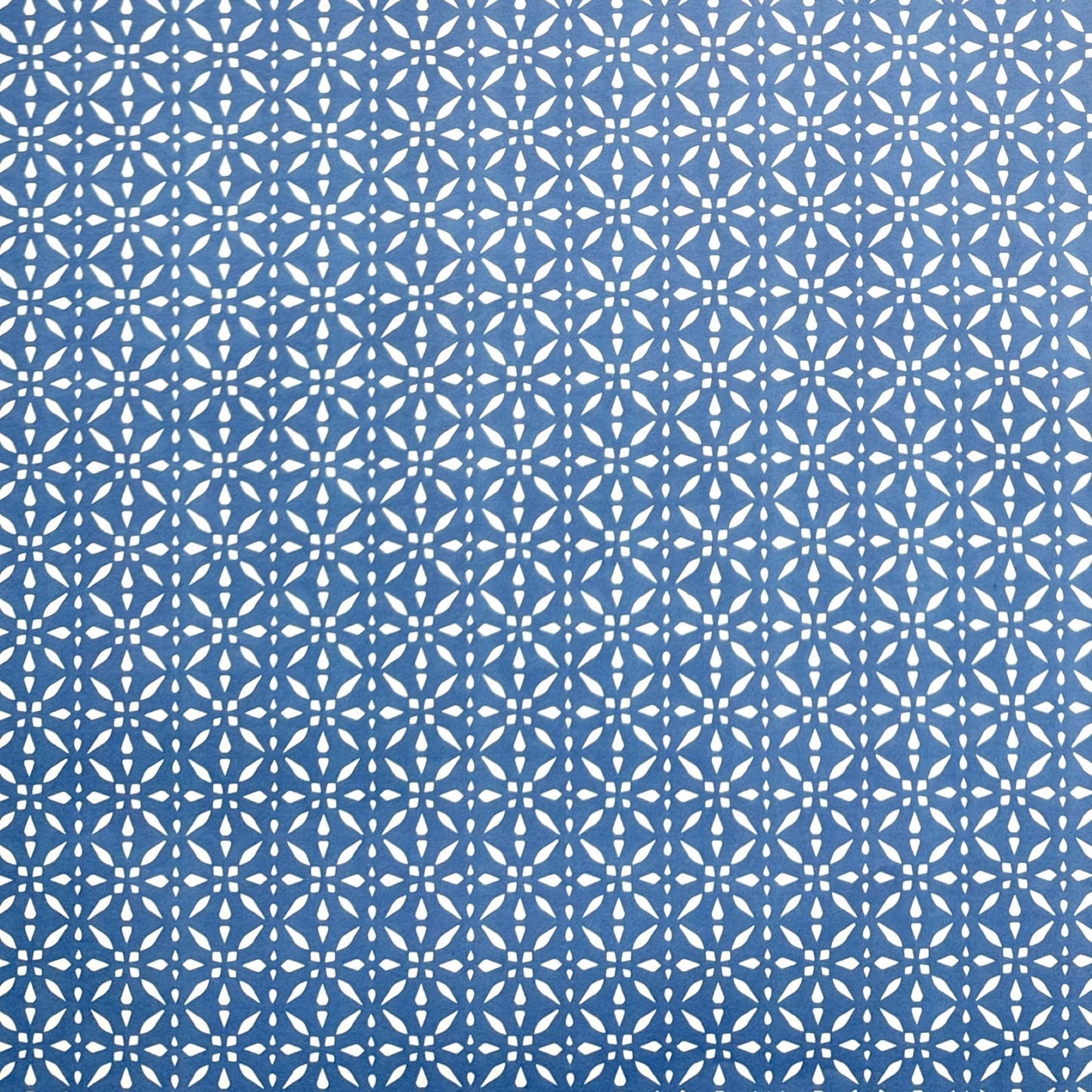 wrapping paper by Otto Editions with a cut-out design in white on a sky blue background.
