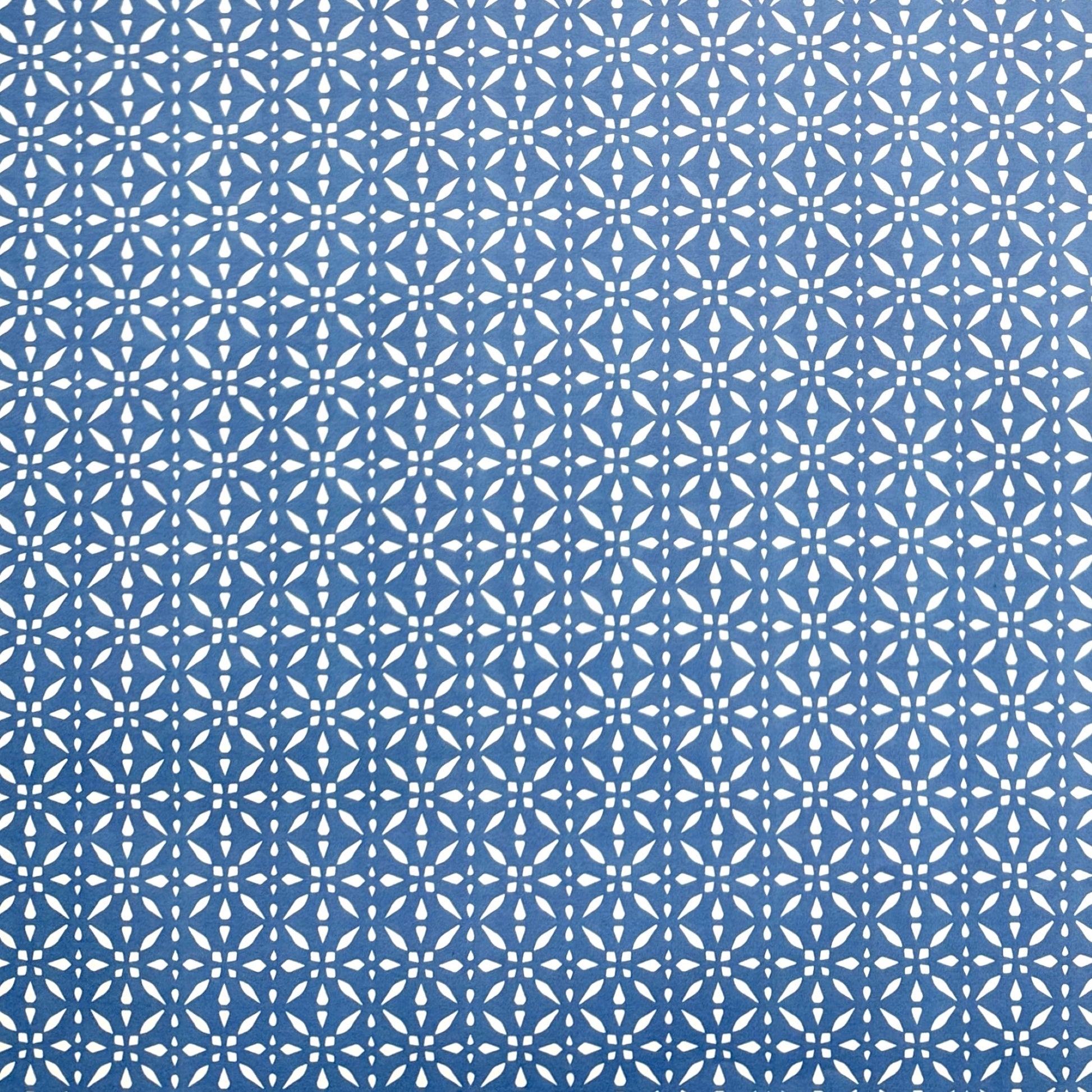 wrapping paper by Otto Editions with a cut-out design in white on a sky blue background.