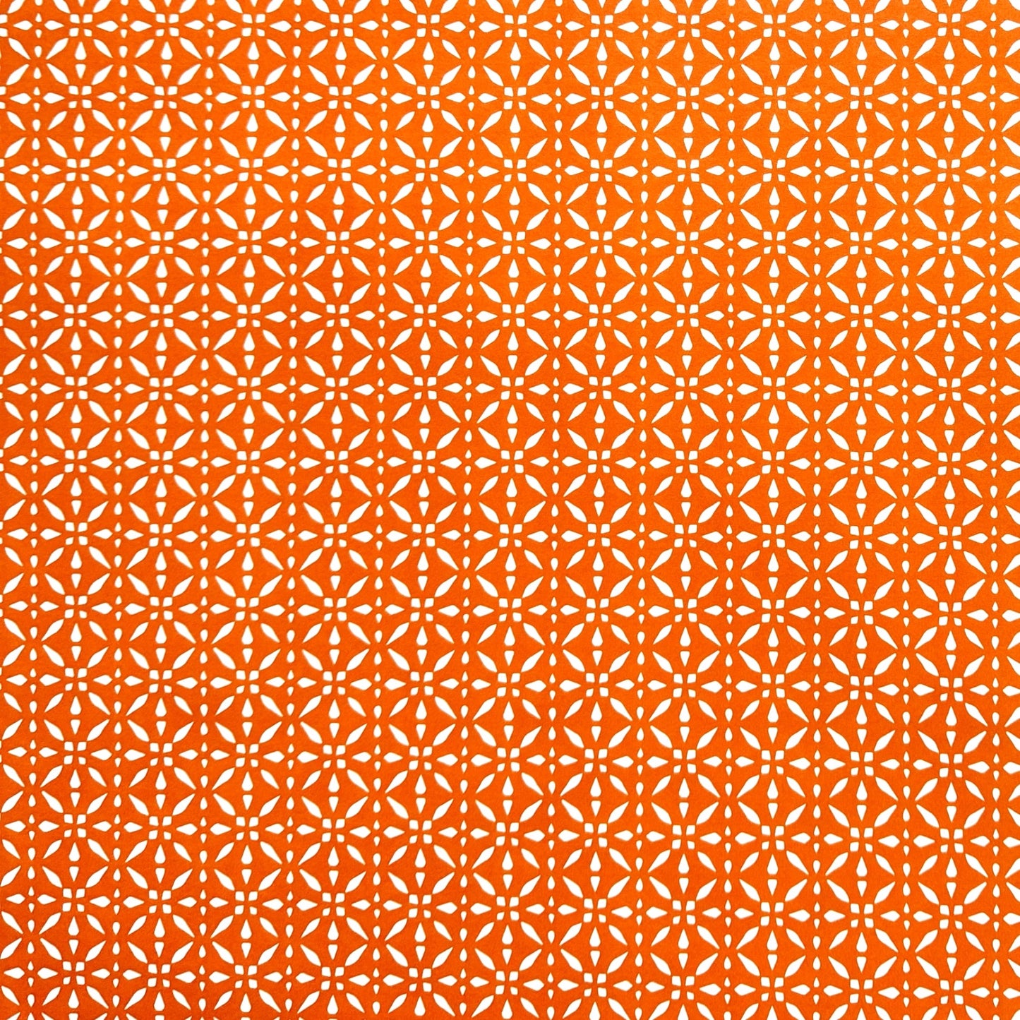 wrapping paper by Otto Editions with a cut-out design in white on a spice orange background.