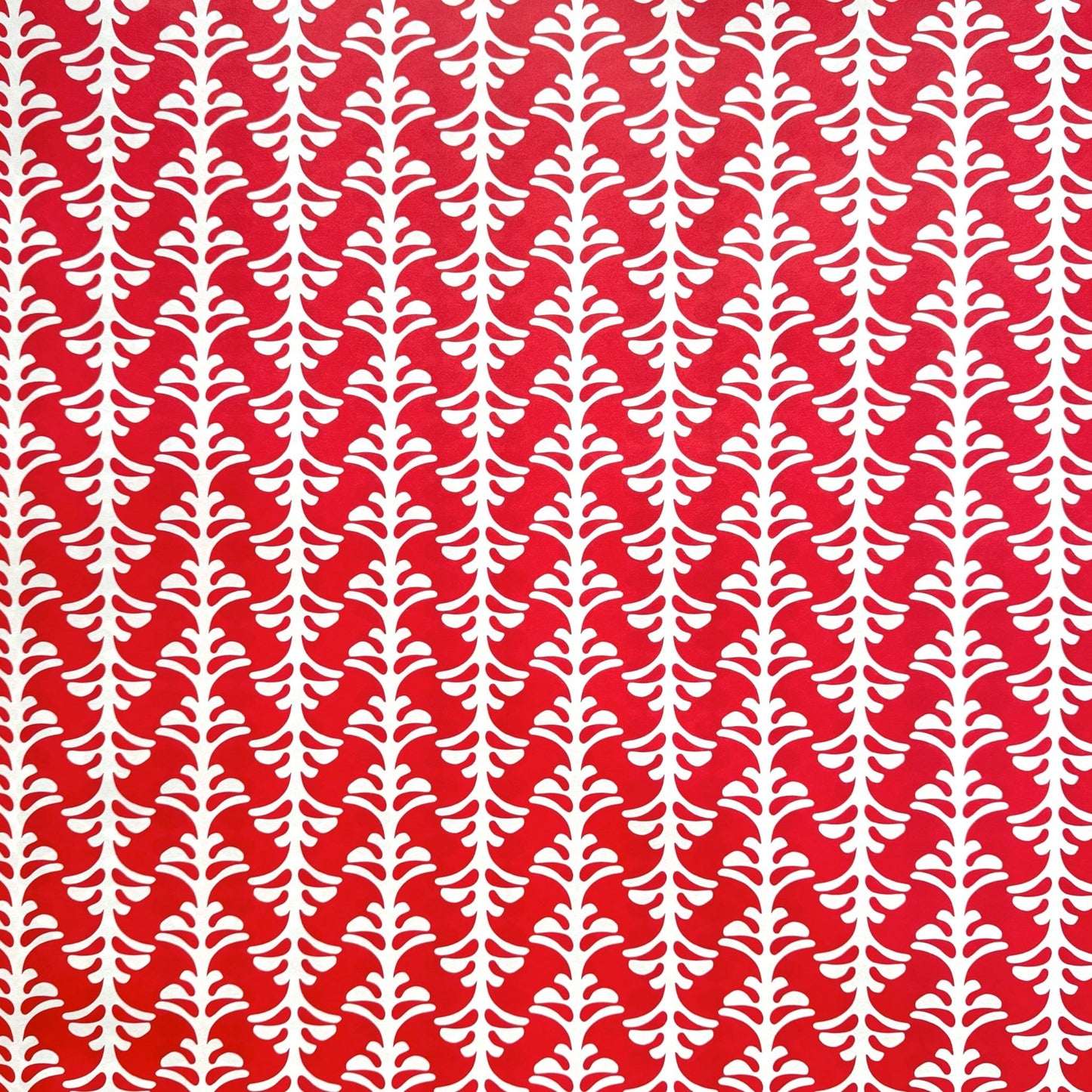 wrapping paper by Otto Editions with a cut-out palm design in white on a hibiscus pink background.