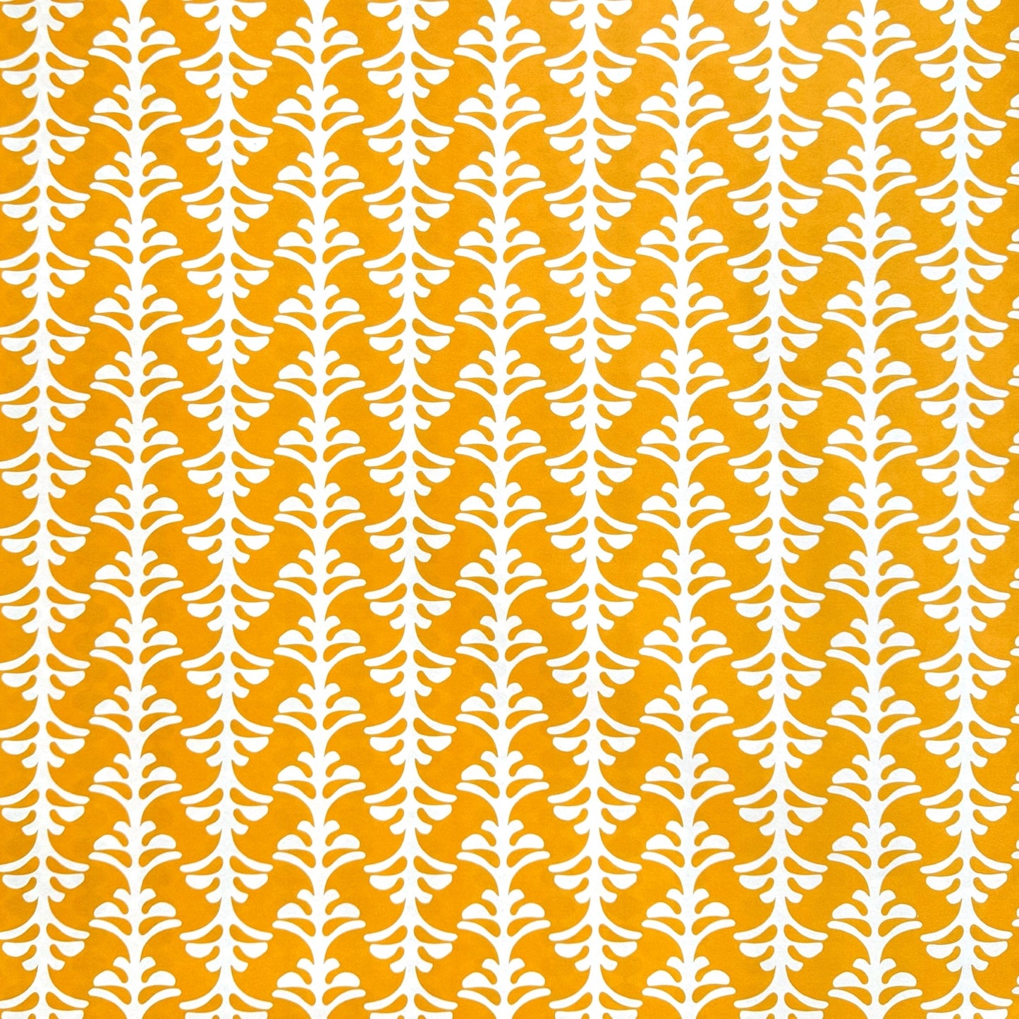 wrapping paper by Otto Editions with a cut-out palm design in white on a saffron yellow background.