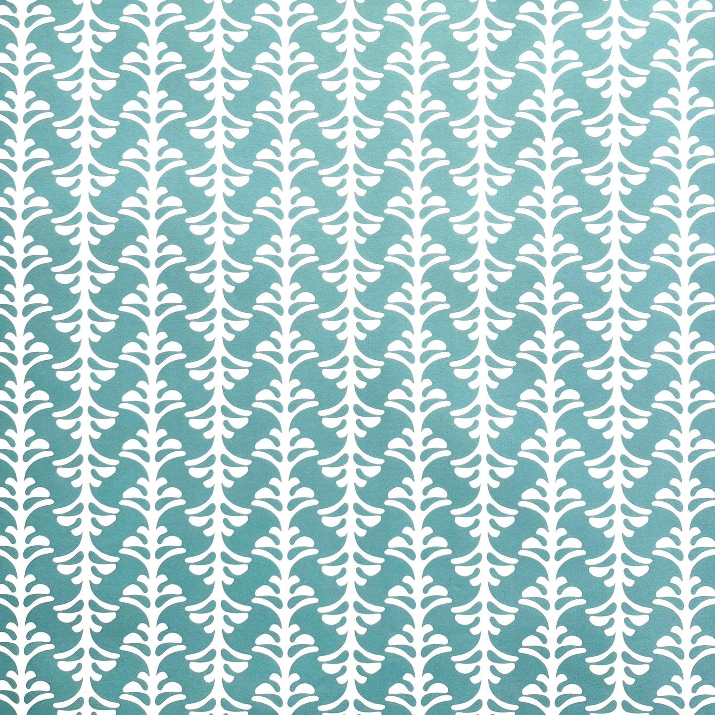 wrapping paper by Otto Editions with a cut-out palm design in white on an aqua blue background.