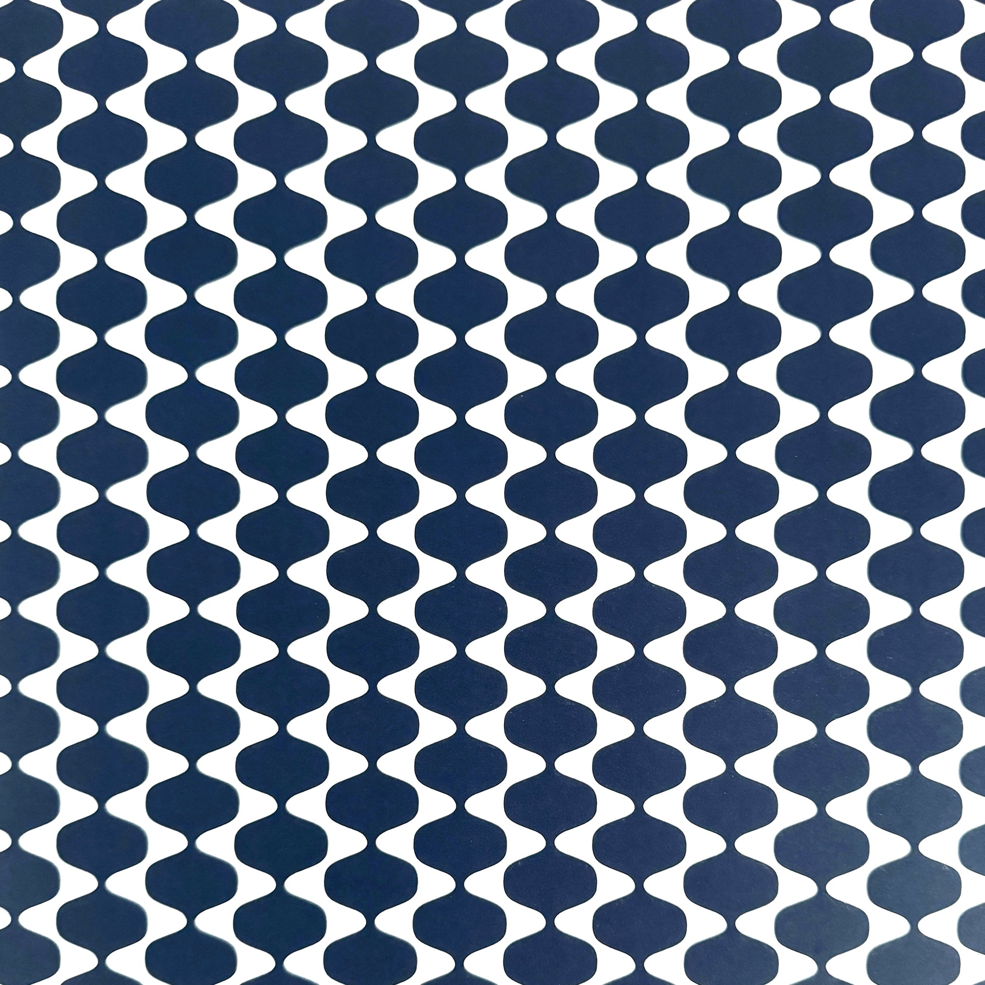 wrapping paper by Otto Editions with a cut-out wavy design in white on an indigo background.