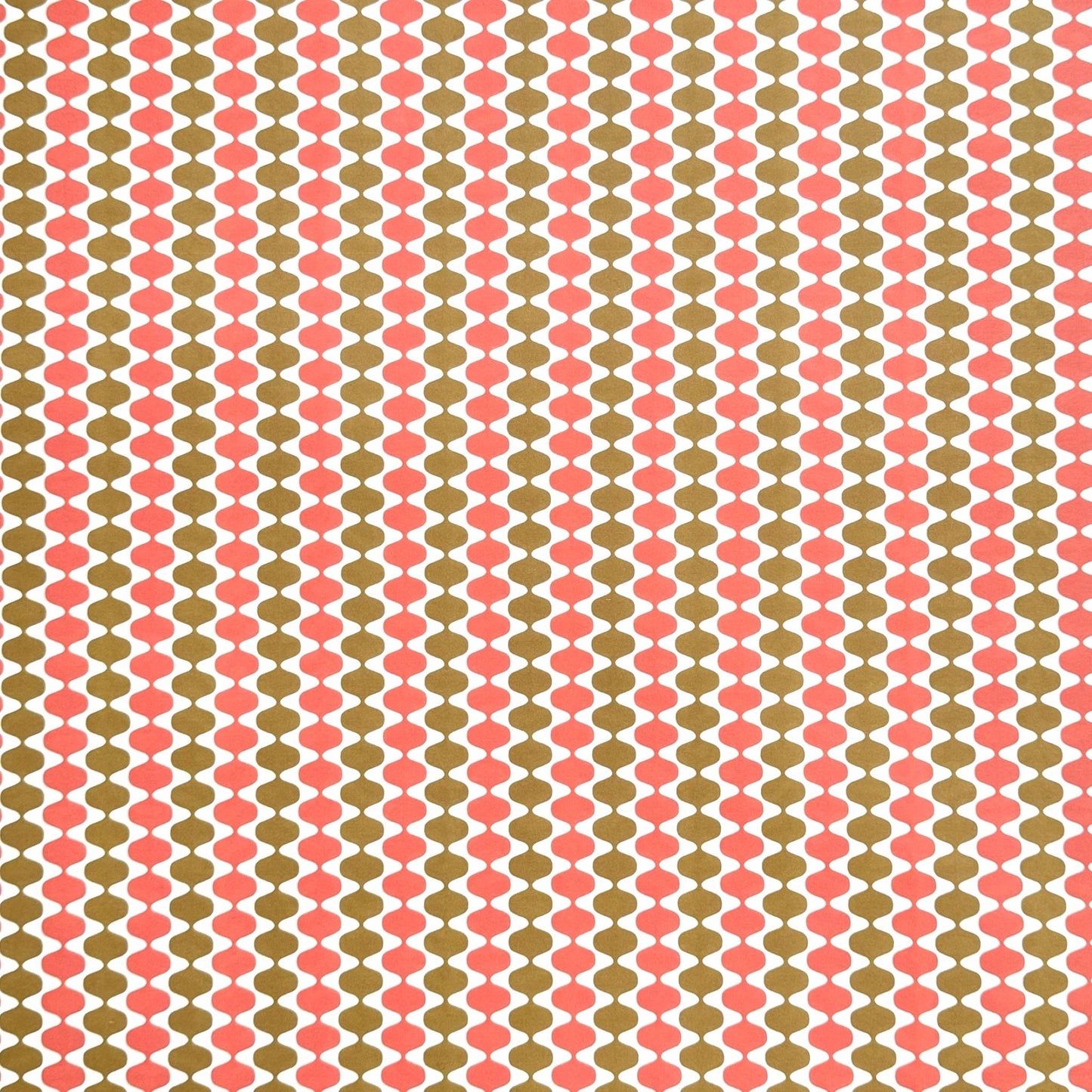 wrapping paper by Otto Editions with a cut-out wavy design in white on a coral and gold background.