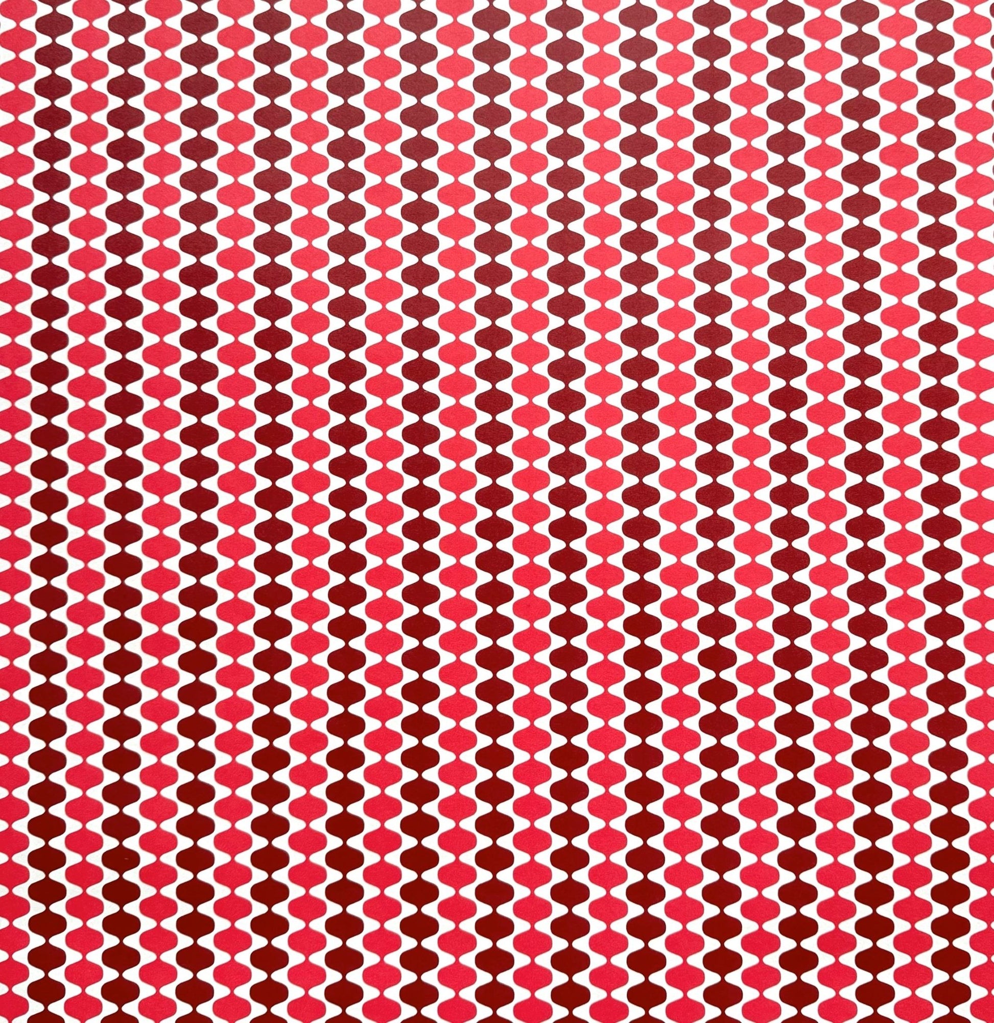 wrapping paper by Otto Editions with a cut-out wavy design in white on a pink and burgundy background.