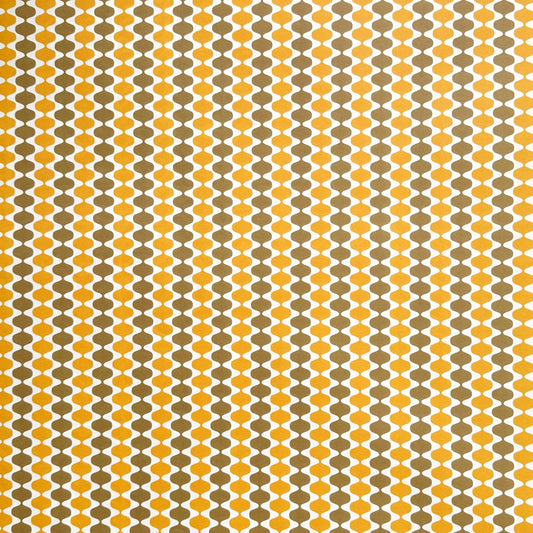 wrapping paper by Otto Editions with a cut-out wavy design in white on a yellow and gold background.