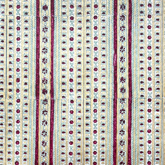 Hand block printed wrapping paper with a striped design in red, green and gold.