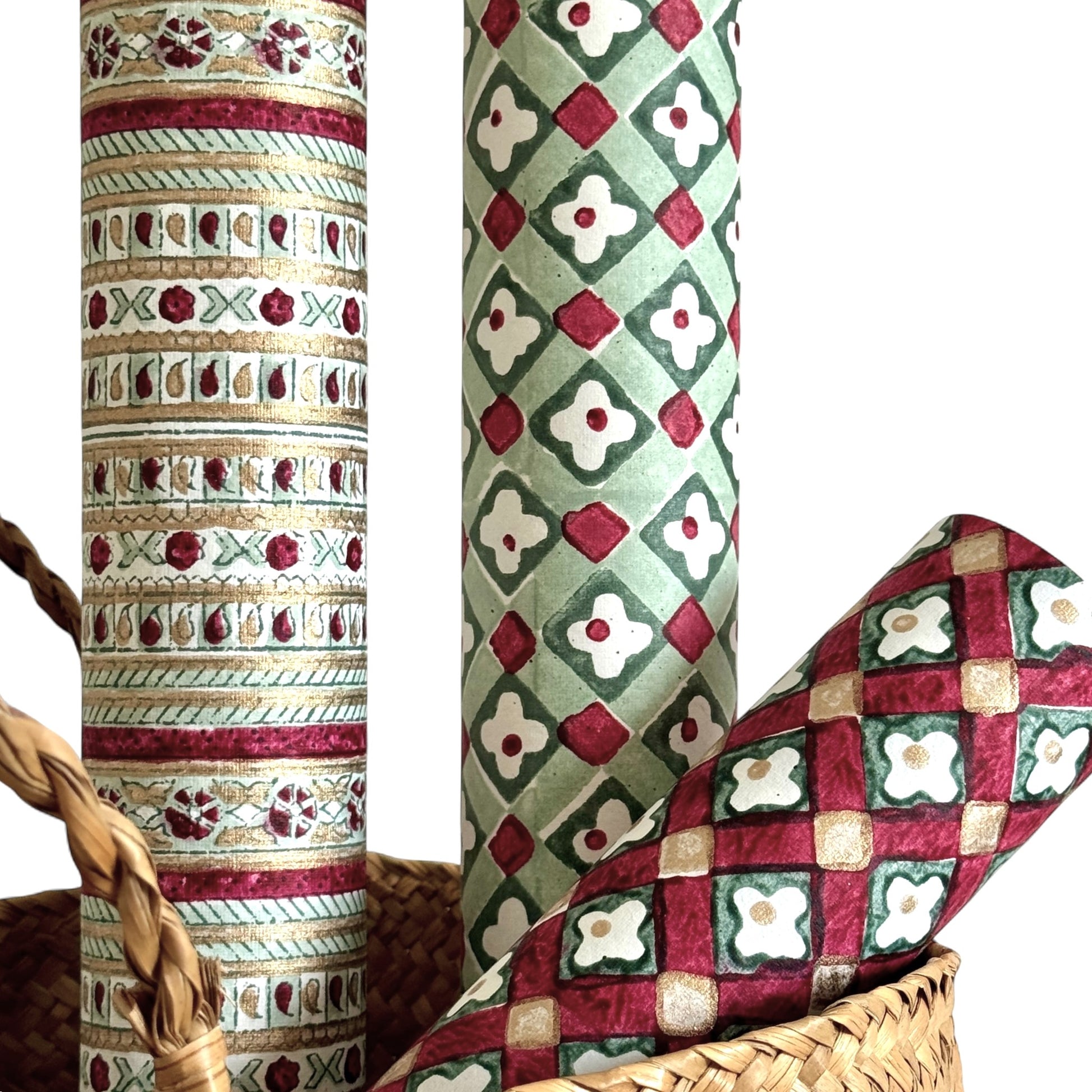 Hand block printed wrapping paper with a striped design in red, green and gold. Close up, pictured alongside other designs