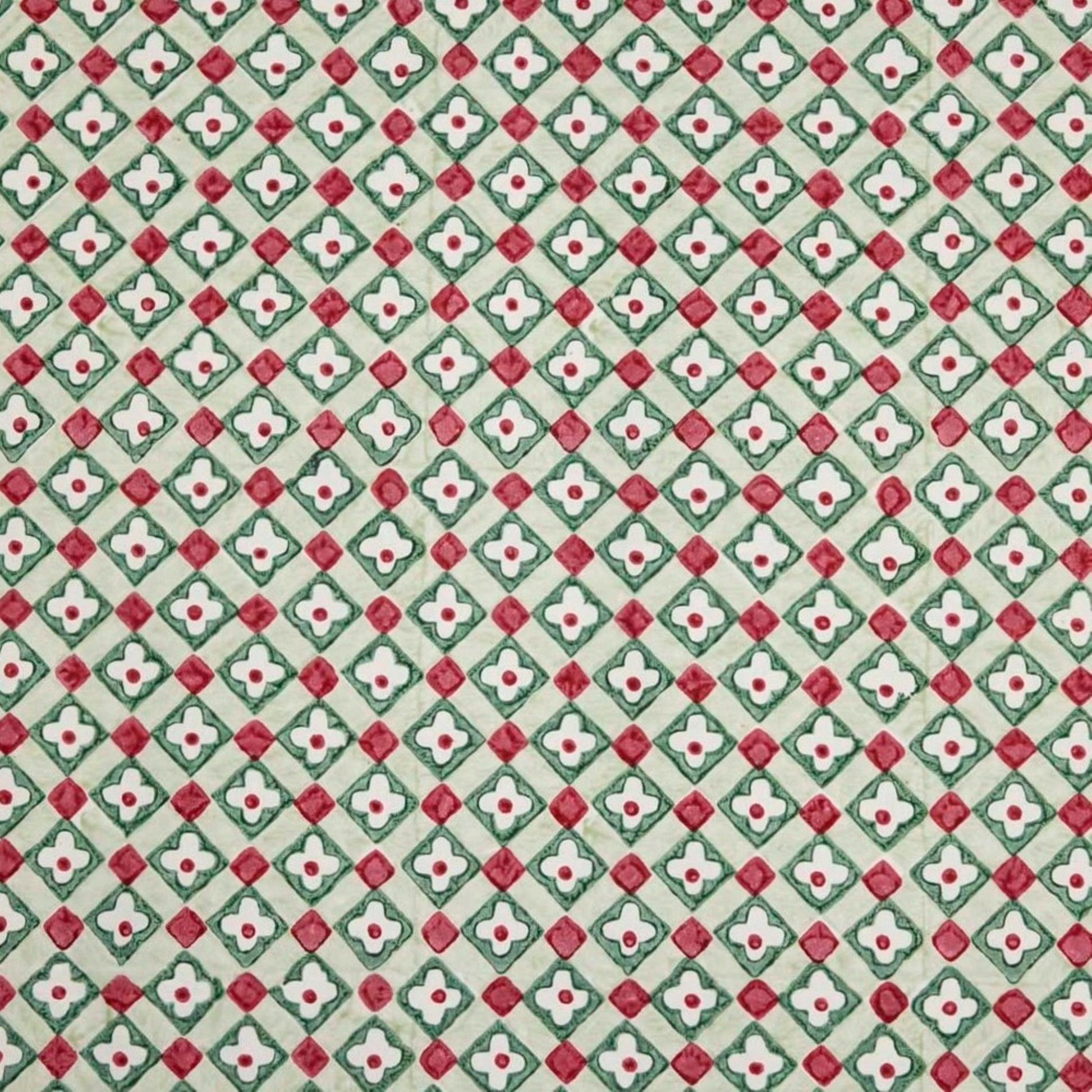 Hand block printed wrapping paper with a floral checked pattern in sage green and red.
