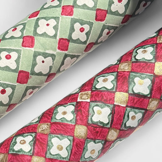 Hand block printed wrapping paper with a floral checked pattern in sage green and red. Close up