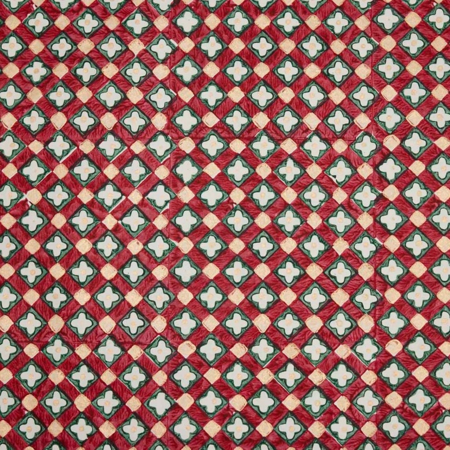 Hand block printed wrapping paper with a floral checked pattern in red, green and gold.