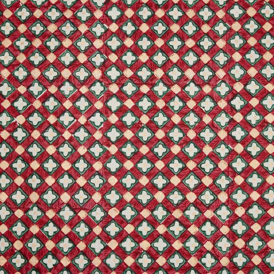 Hand block printed wrapping paper with a floral checked pattern in red, green and gold.