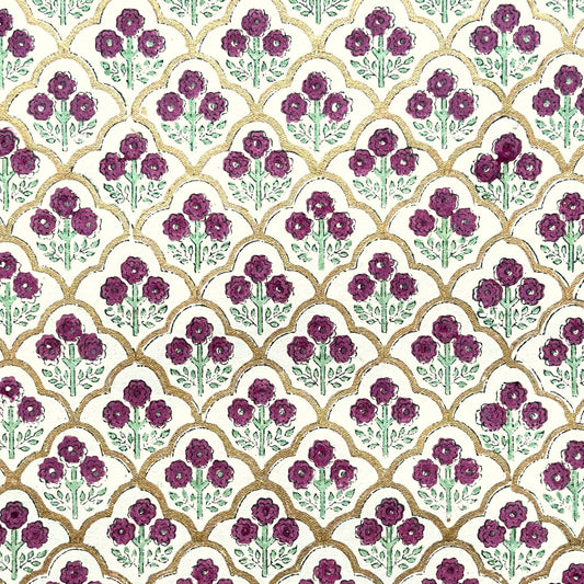 Hand block printed wrapping paper with a trellis pattern with flowers in cherry red, green and gold.