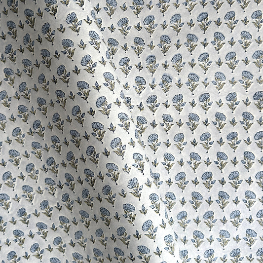 a hand block printed sheet of wrapping paper with a ditsy floral print in soft blue
