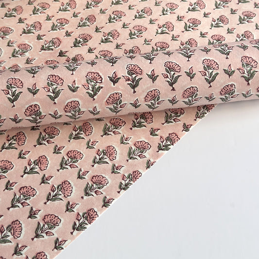 a hand block printed sheet of wrapping paper with a ditsy floral print in pink