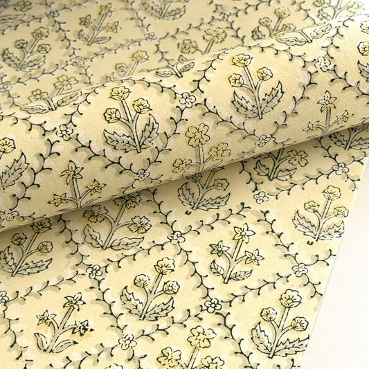 a sheet of hand block printed wrapping paper with a floral lattice design in soft buttermilk yellow
