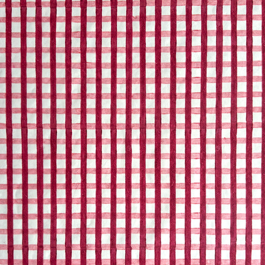 red and pink gingham pattern hand block printed on a white sheet of cotton paper
