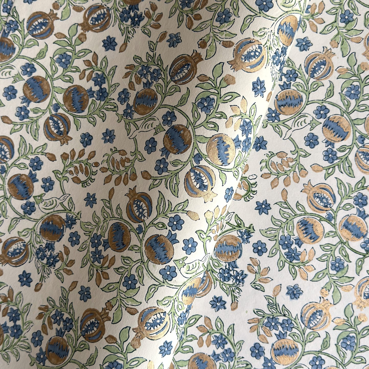 hand block printed wrapping paper with a pomegranate design in indigo and green with gold accent. By Paper Mirchi