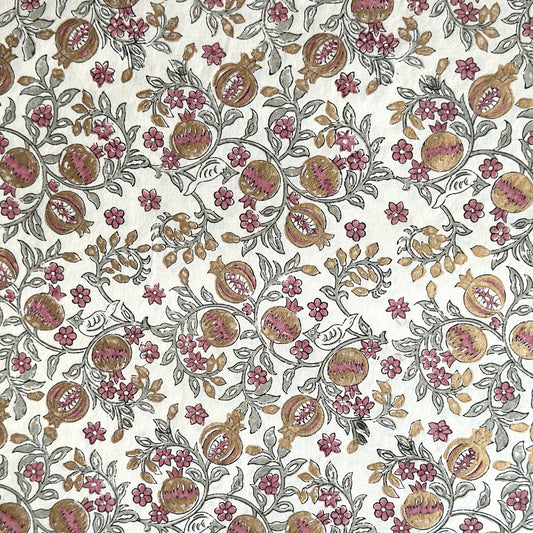 hand block printed wrapping paper by Paper Mirchi. Repeat pattern of pomegranates in pink and green within a gold accent design.