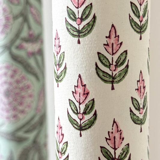 hand block printed paper by Paper Mirchi. Repeat design of a stylised flower in blush pink and green on a white background. Close up