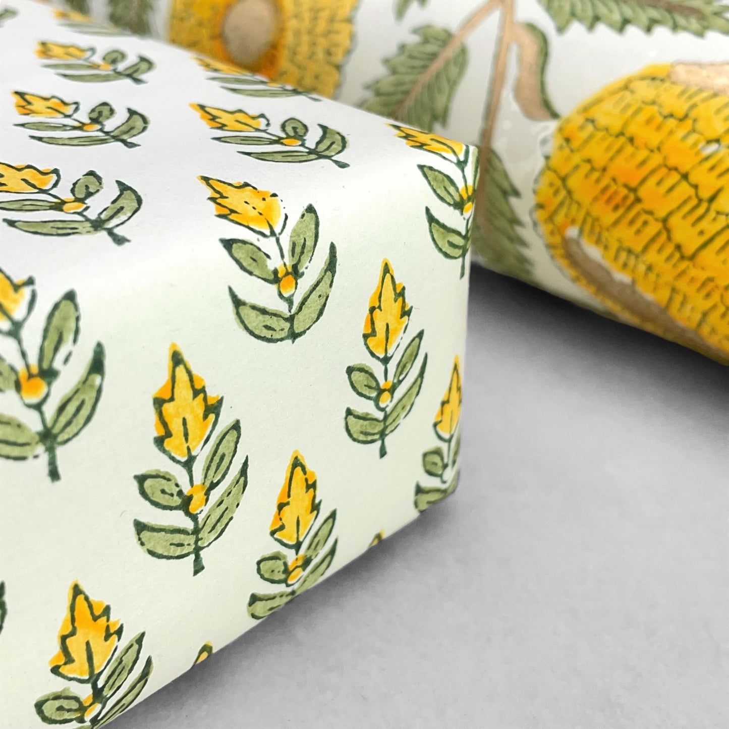 Wrapping paper with block print small flower motif in yellow and green, white background by Paper Mirchi