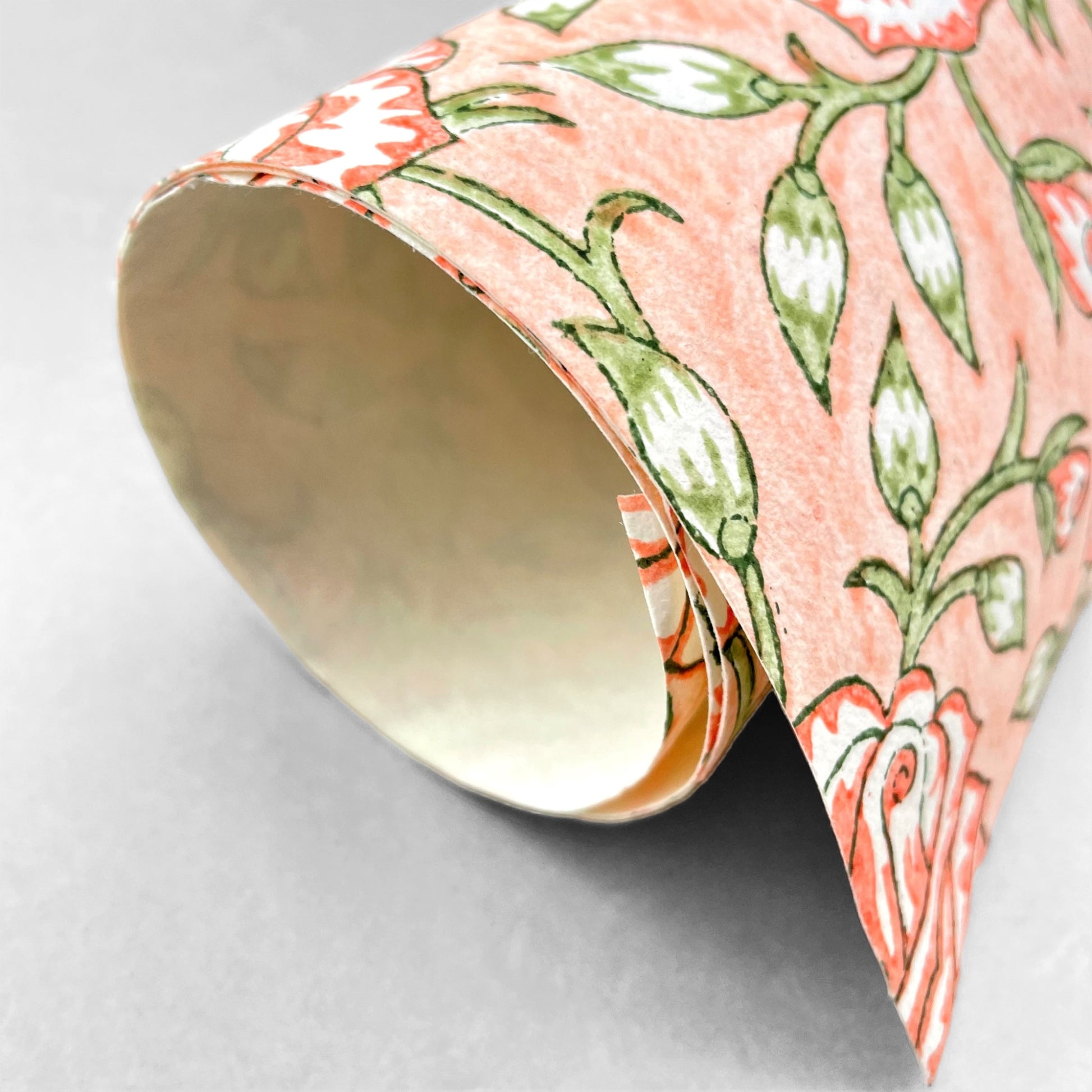 wrapping paper with repeat botanical rose pattern in coral and green by Paper Mirchi