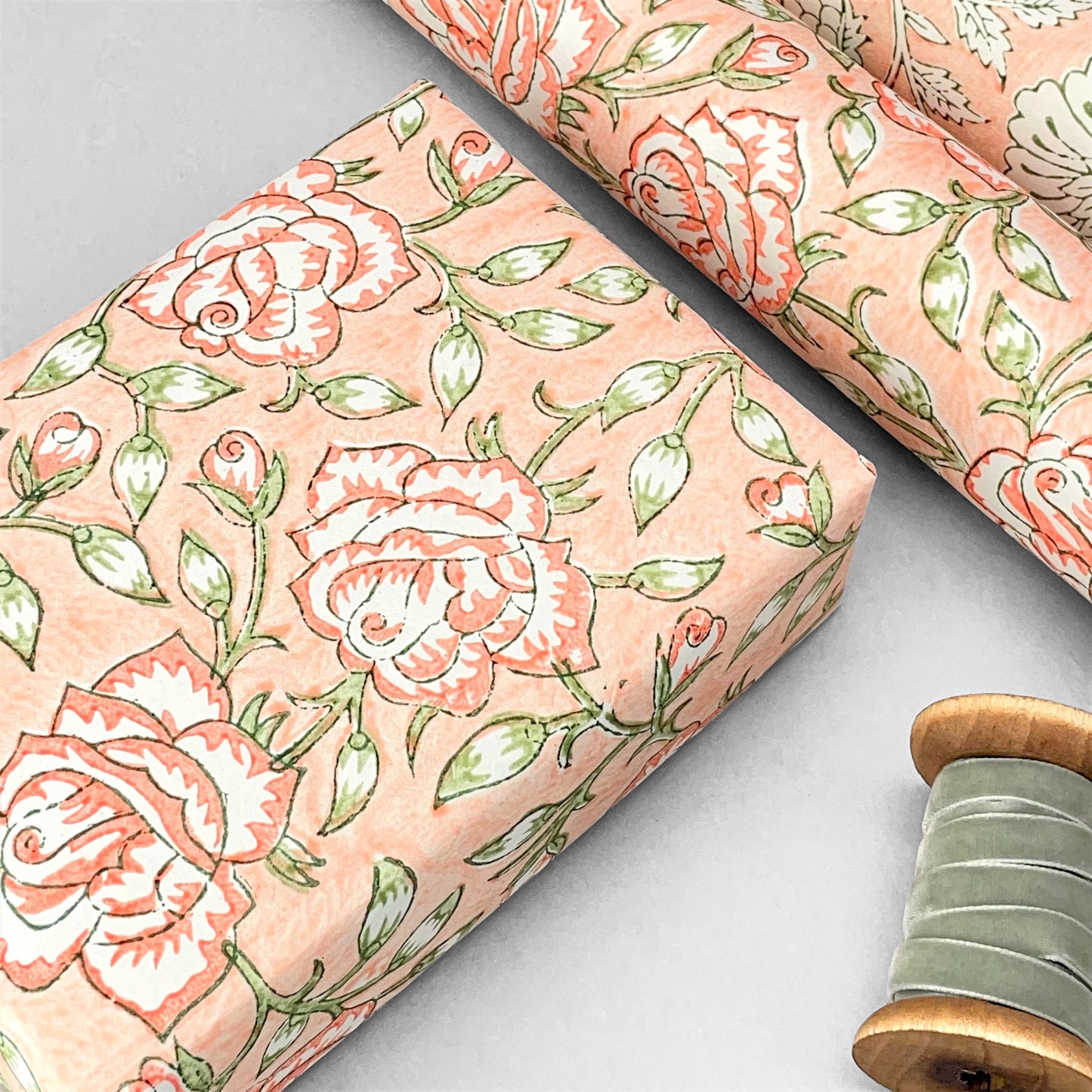 wrapping paper with repeat botanical rose pattern in coral and green by Paper Mirchi
