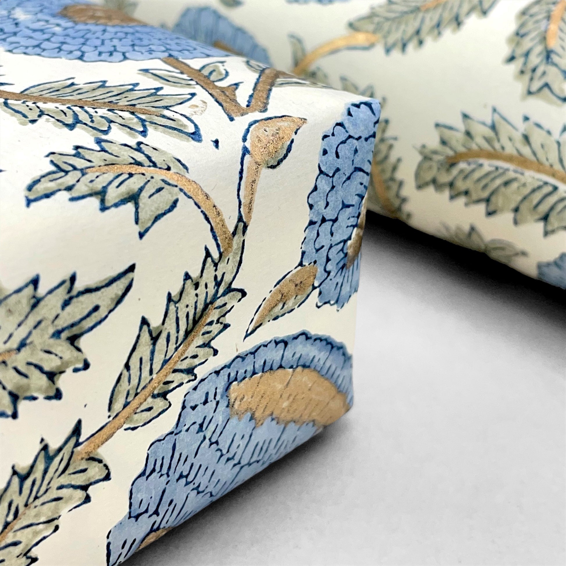 wrapping paper with repeat botanical pattern in blue, gold and green by Paper Mirchi