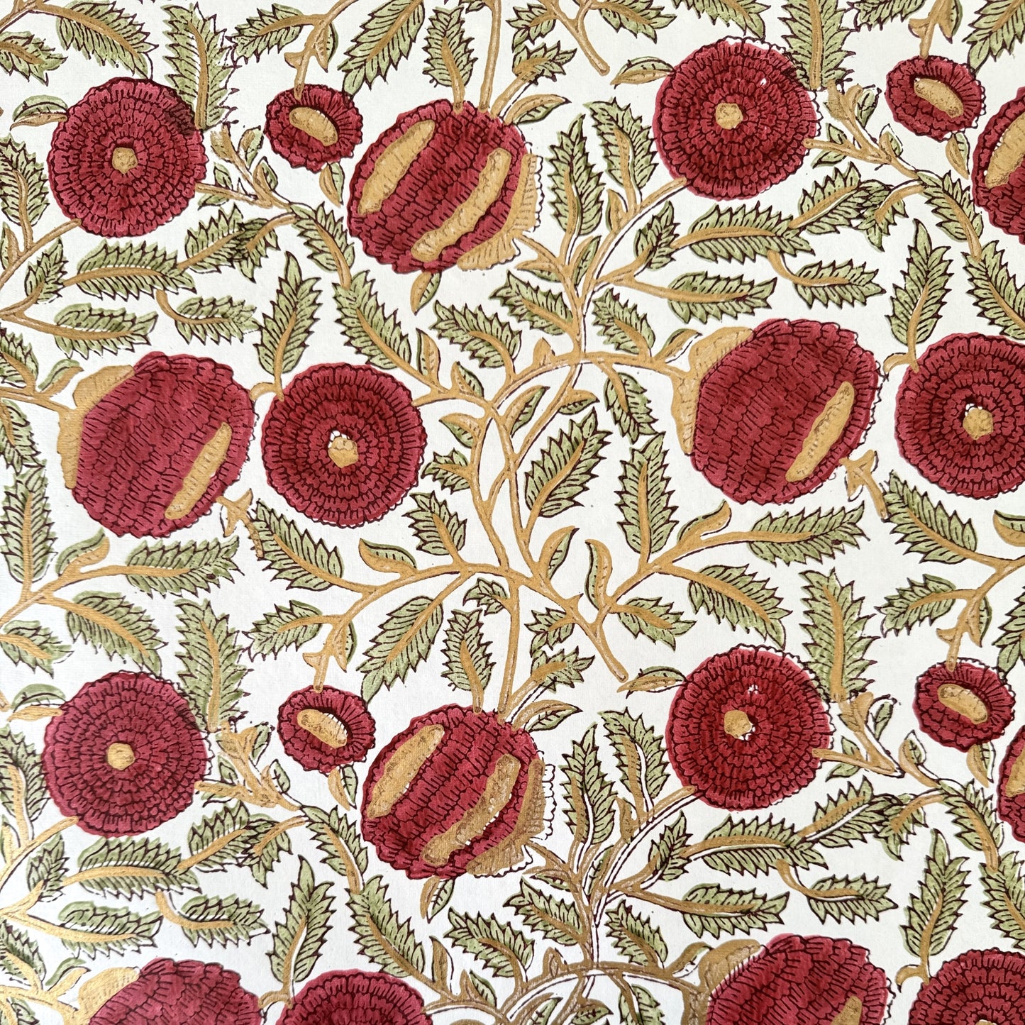 hand block printed paper by Paper Mirchi.  A floral repeat pattern in deep burgundy, pale green and gold.
