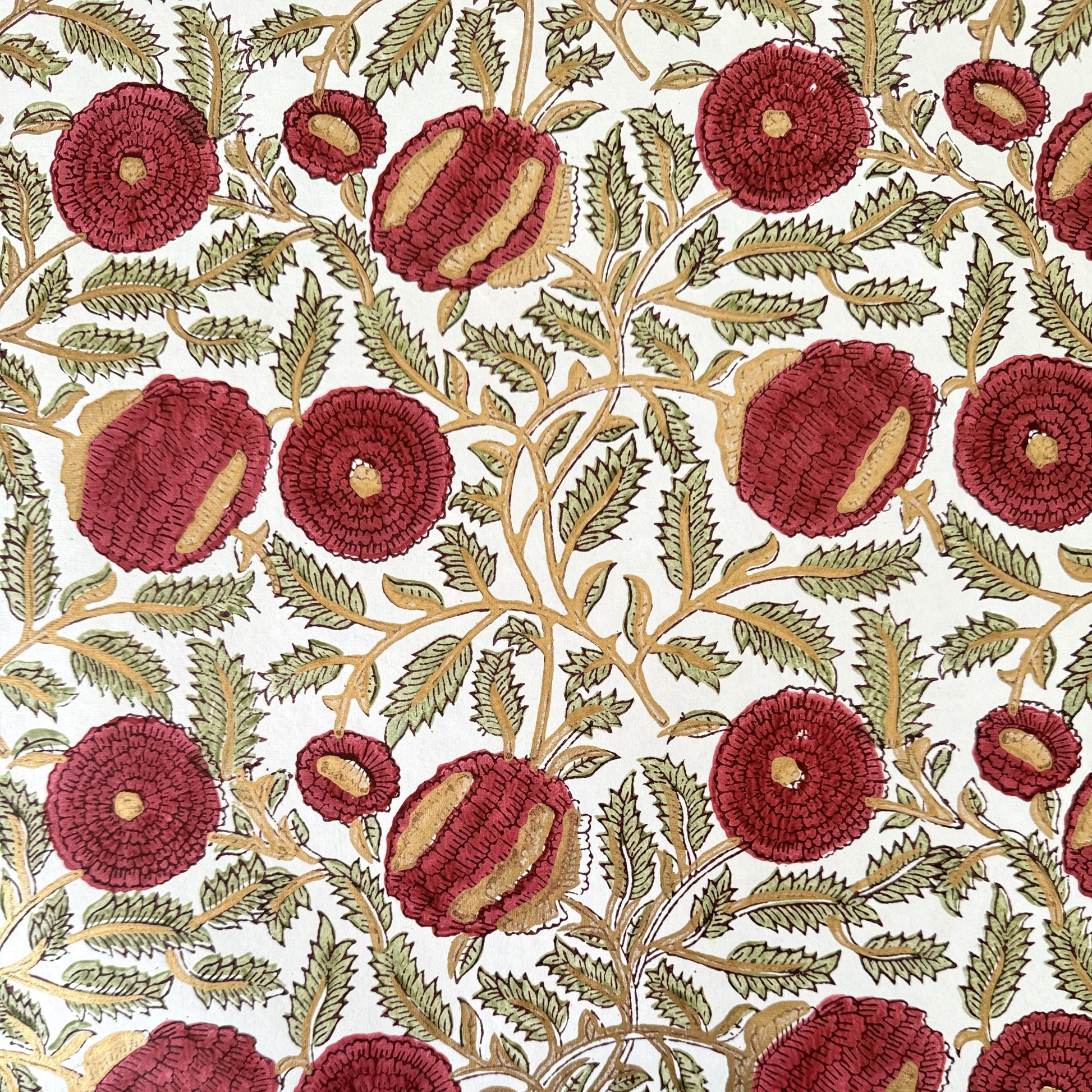 hand block printed paper by Paper Mirchi.  A floral repeat pattern in deep burgundy, pale green and gold.
