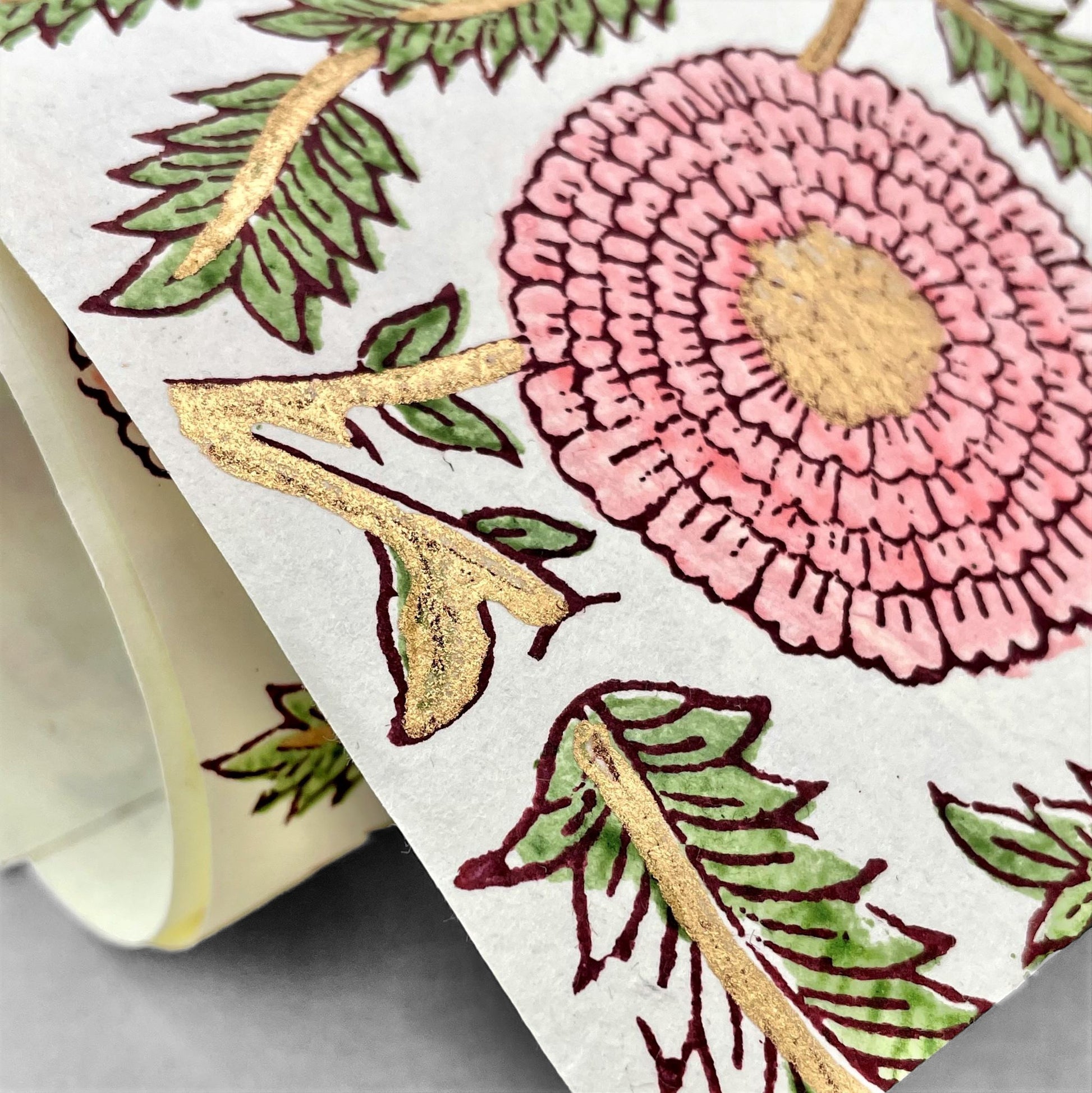 wrapping paper with repeat botanical pattern in pink, gold and green by Paper Mirchi
