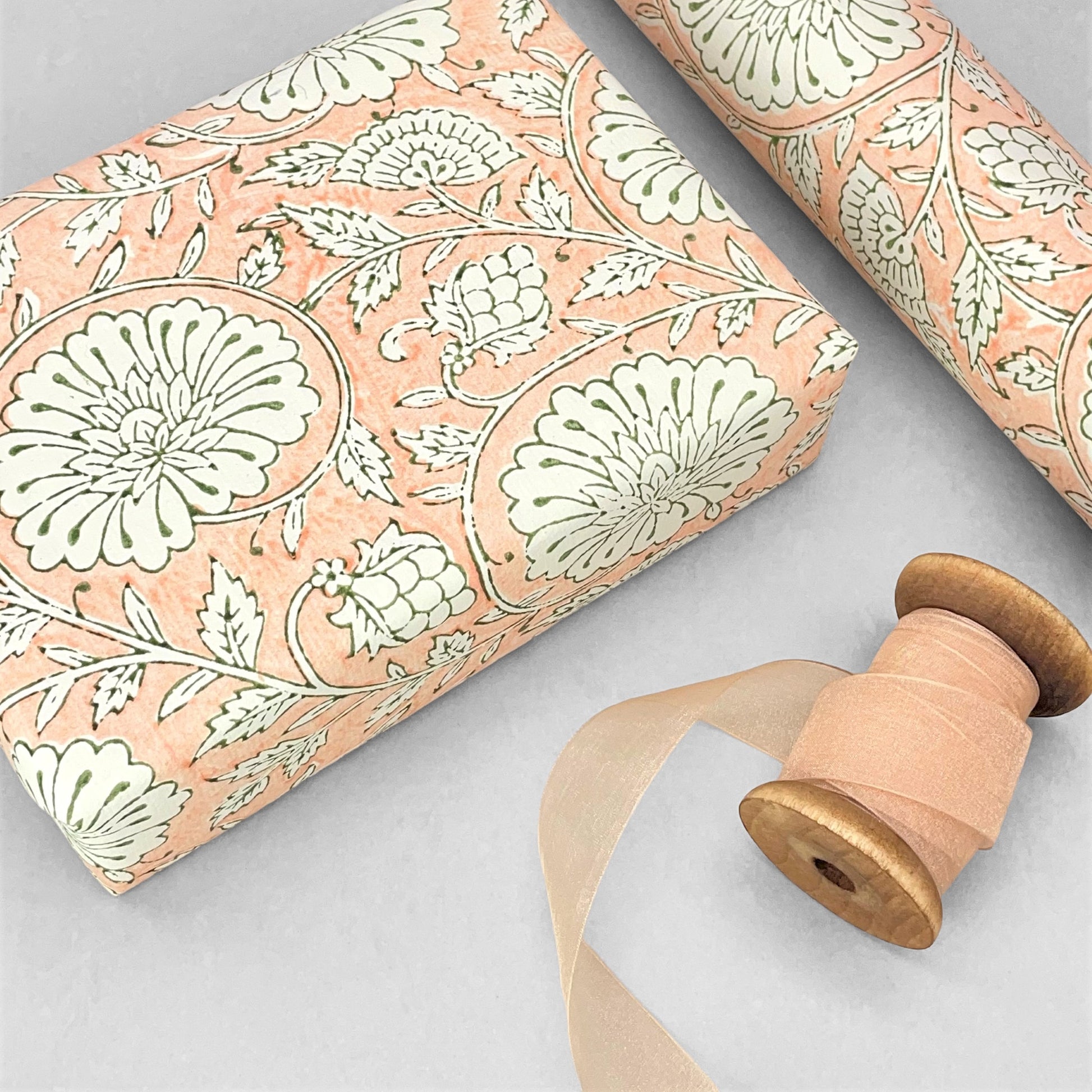 wrapping paper with repeat botanical pattern in light coral pink by Paper Mirchi