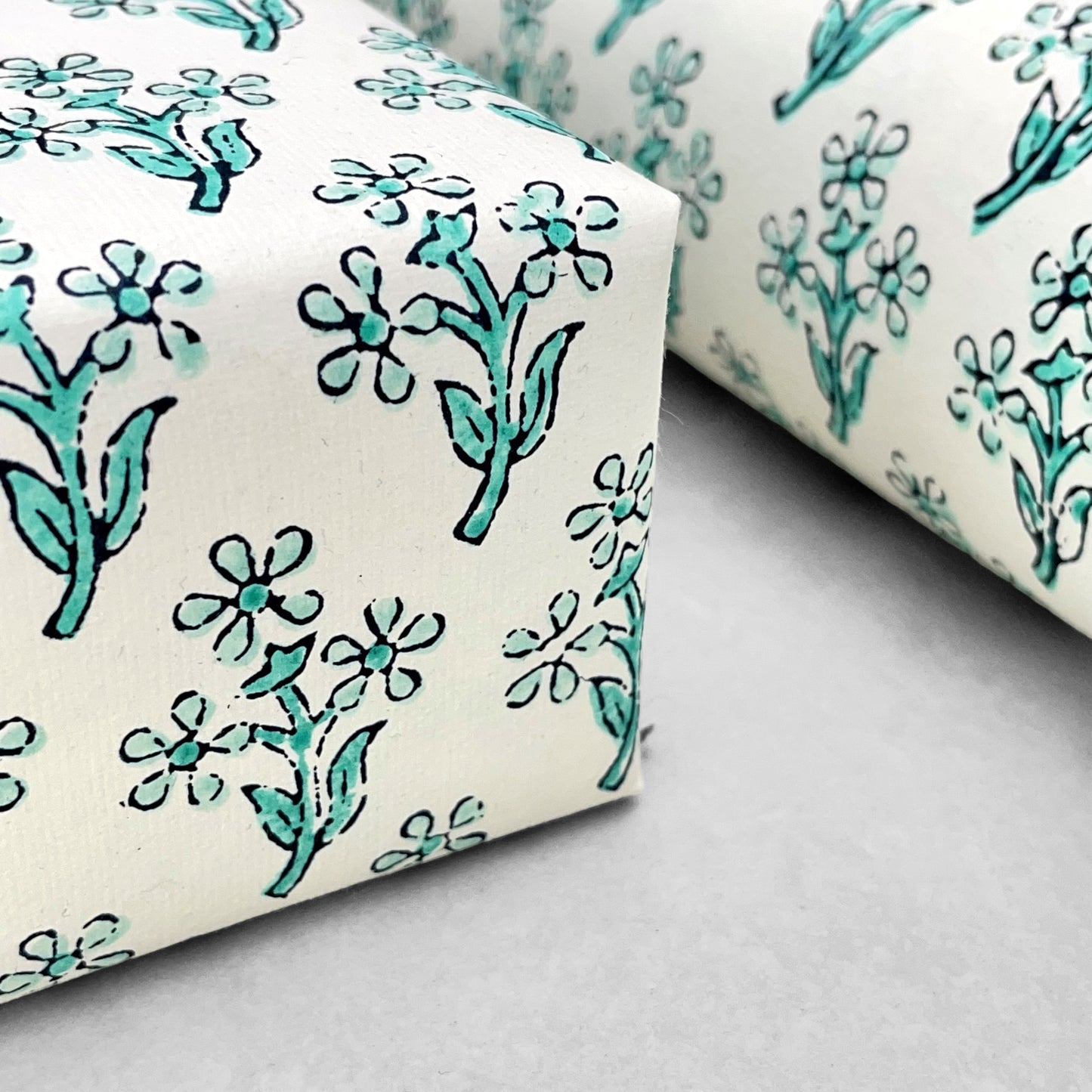 wrapping paper with repeat block print little floral pattern in aqua by Paper Mirchi