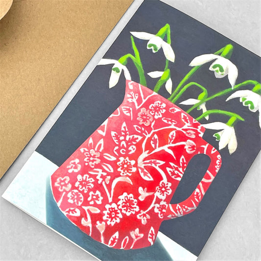 greeting card of a painting of white snowdrops in a red and white patterned jug, dark grey background by Susie Hamilton