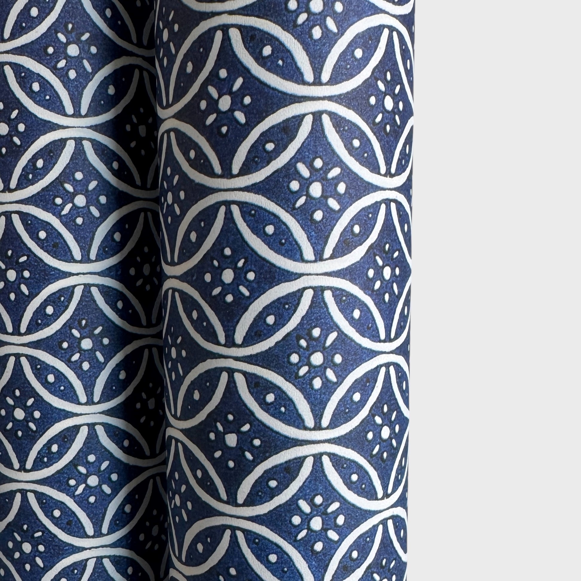 A sheet of Italian wrapping paper with a pattern of interlocking rings on a blue background.  close up