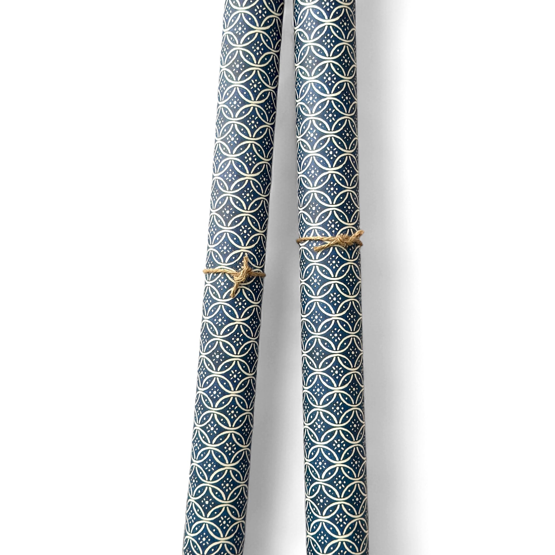 A sheet of Italian wrapping paper with a pattern of interlocking rings on a blue background.  Pictured rolled