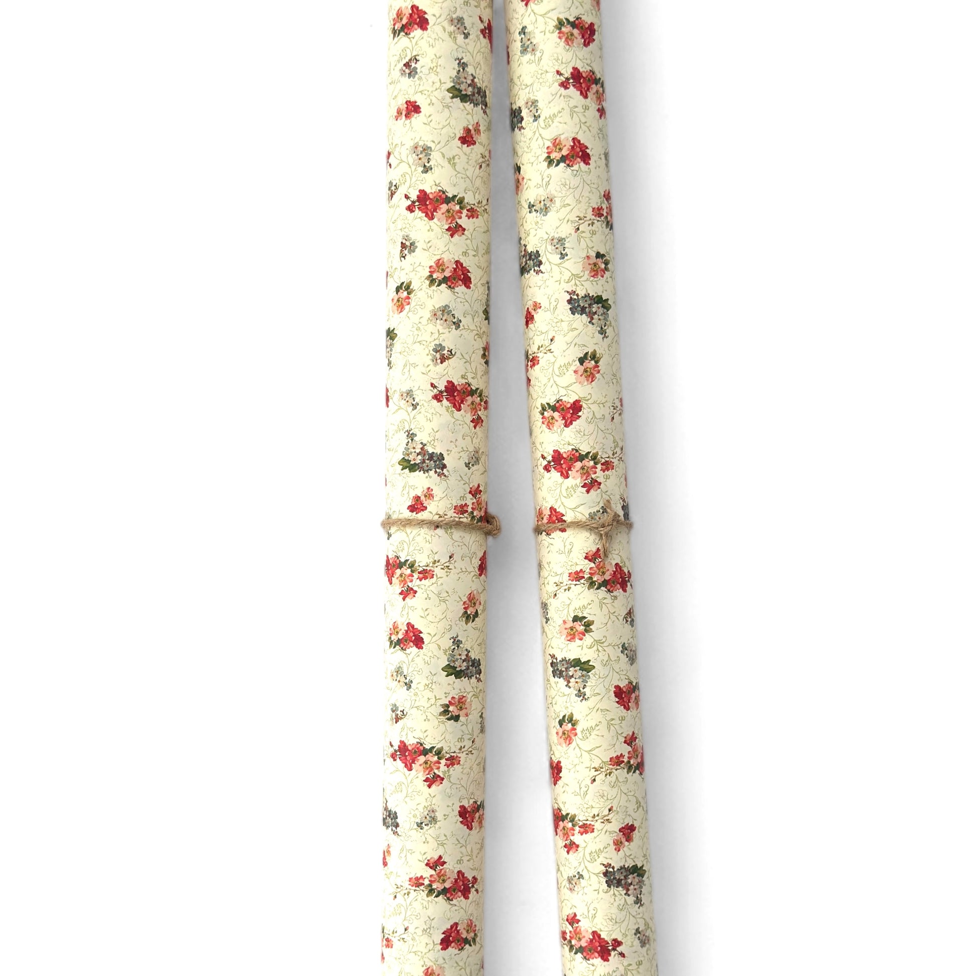 a sheet of italian wrapping paper with a vintage Liberty style floral pattern in red and green on cream. Pictured rolled