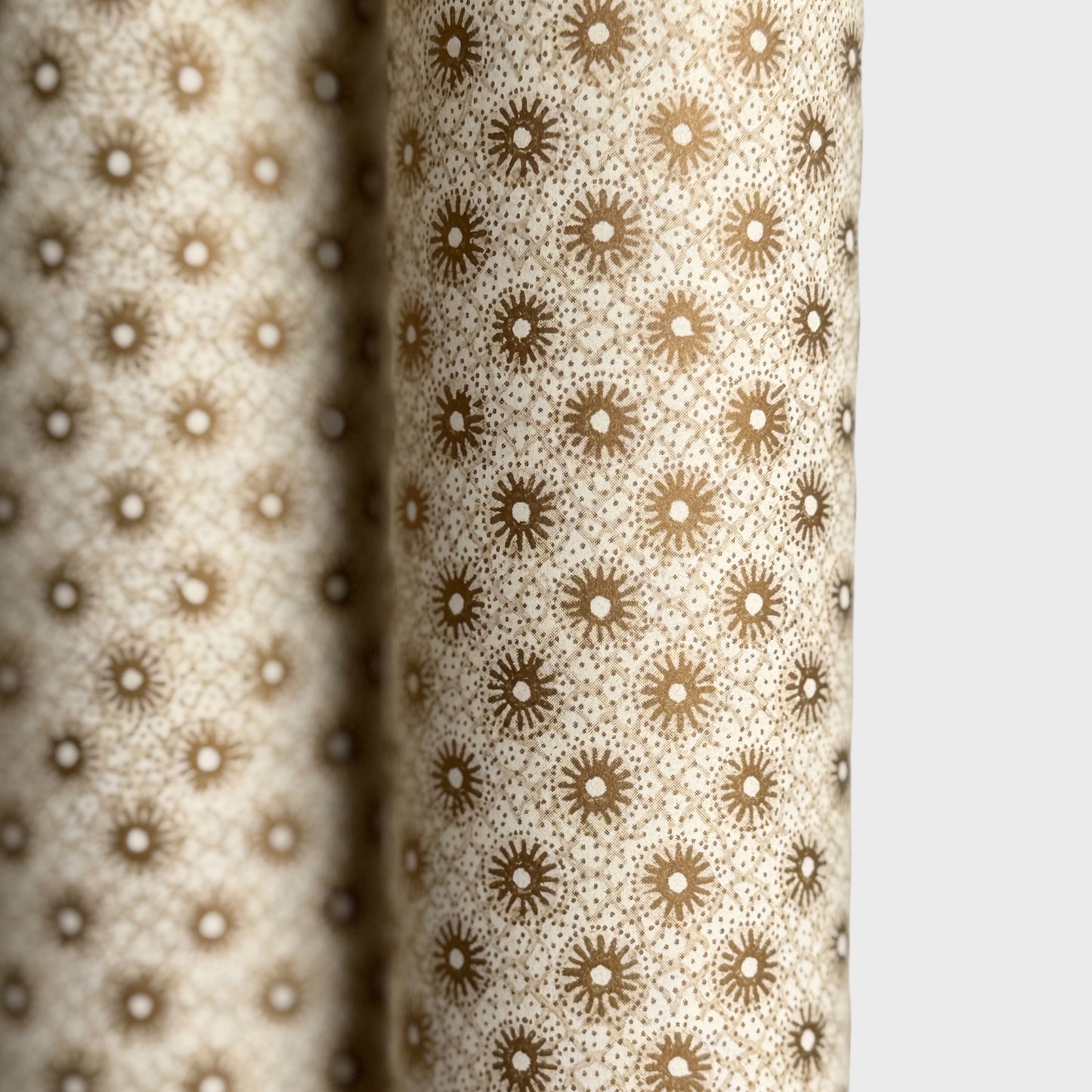 a sheet of italian wrapping paper with gold snowflakes on a cream backdrop. Close up