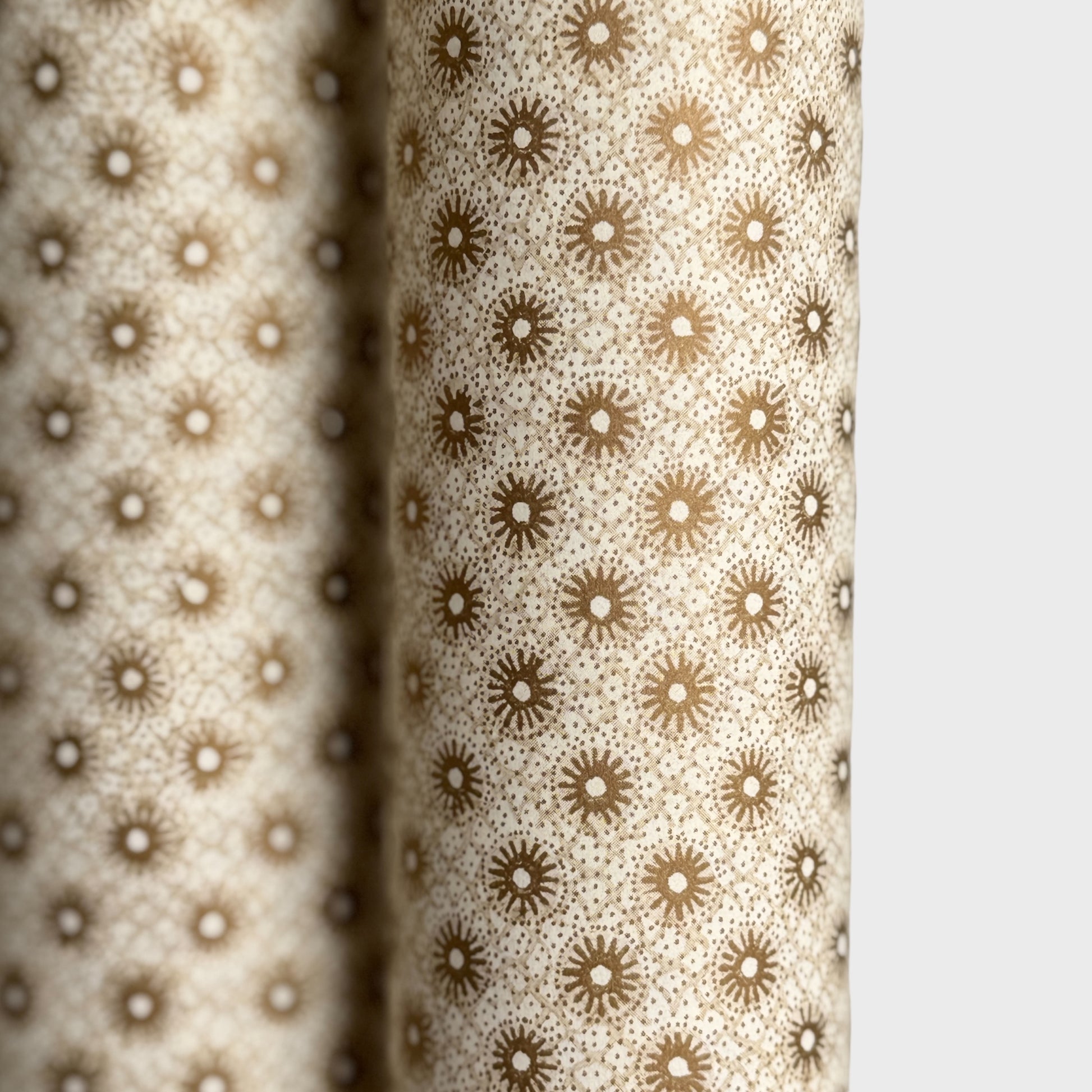 a sheet of italian wrapping paper with gold snowflakes on a cream backdrop. Close up