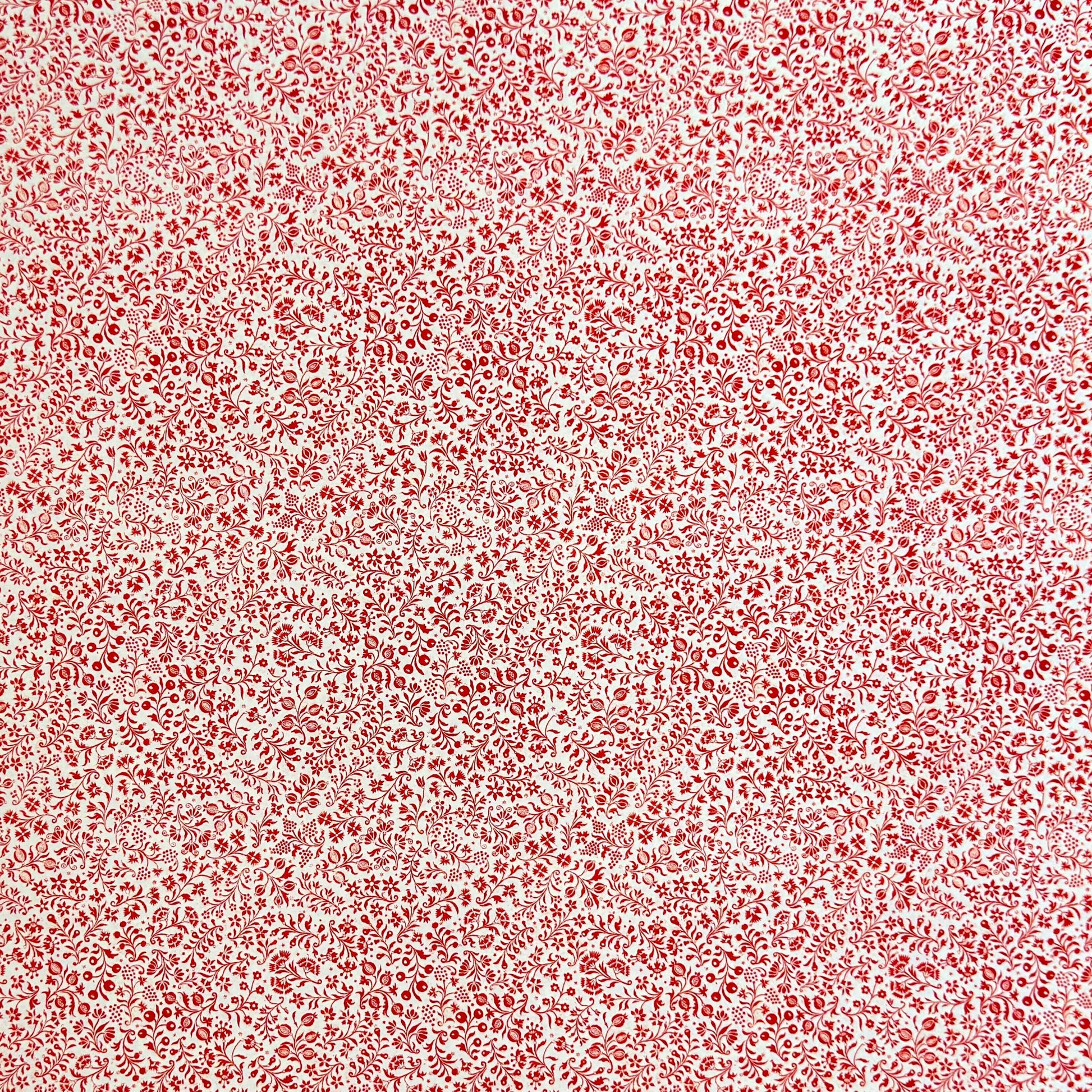 a sheet of italian wrapping paper with a small delicate floral pattern in red on white background