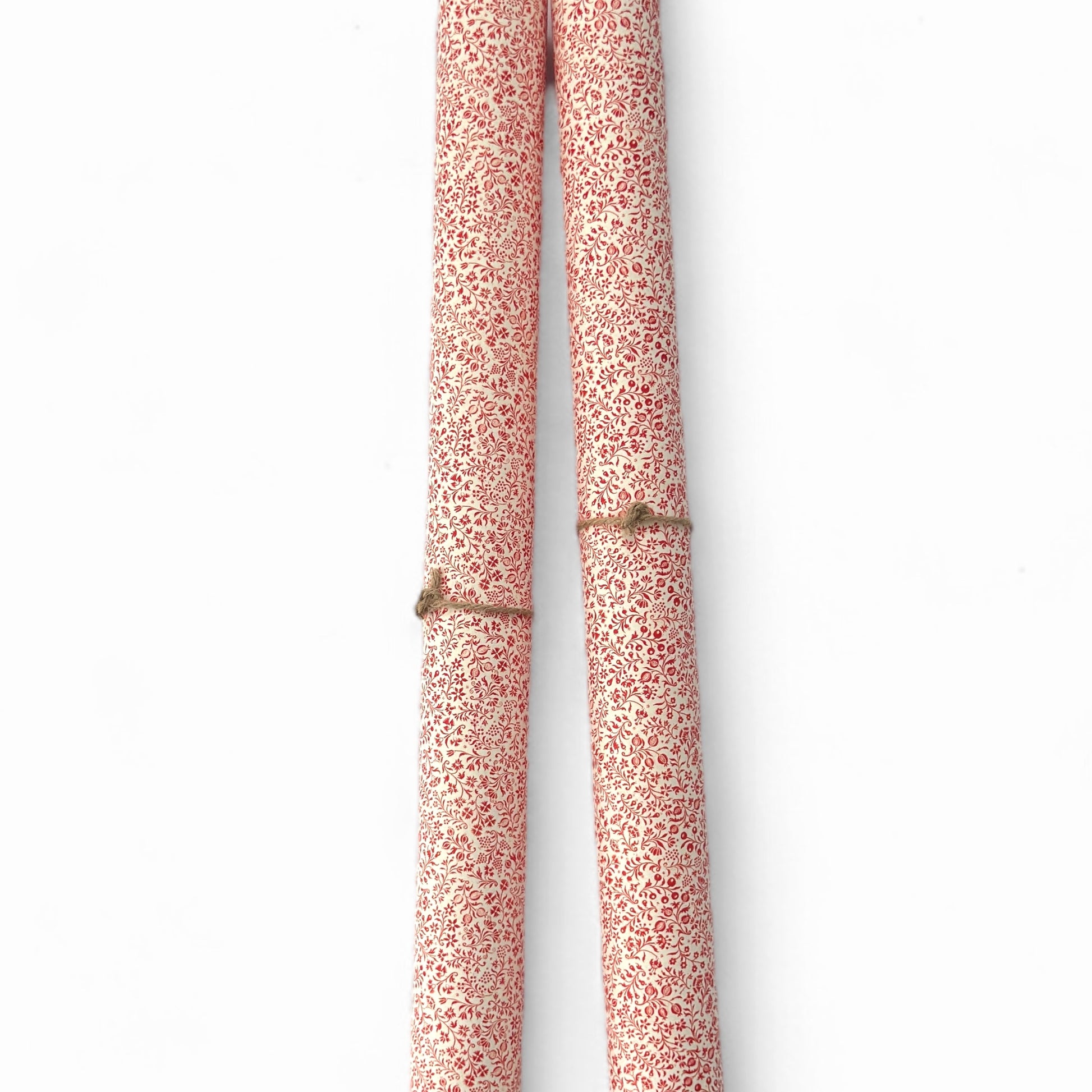 a sheet of italian wrapping paper with a small delicate floral pattern in red on white background. Pictured rolled