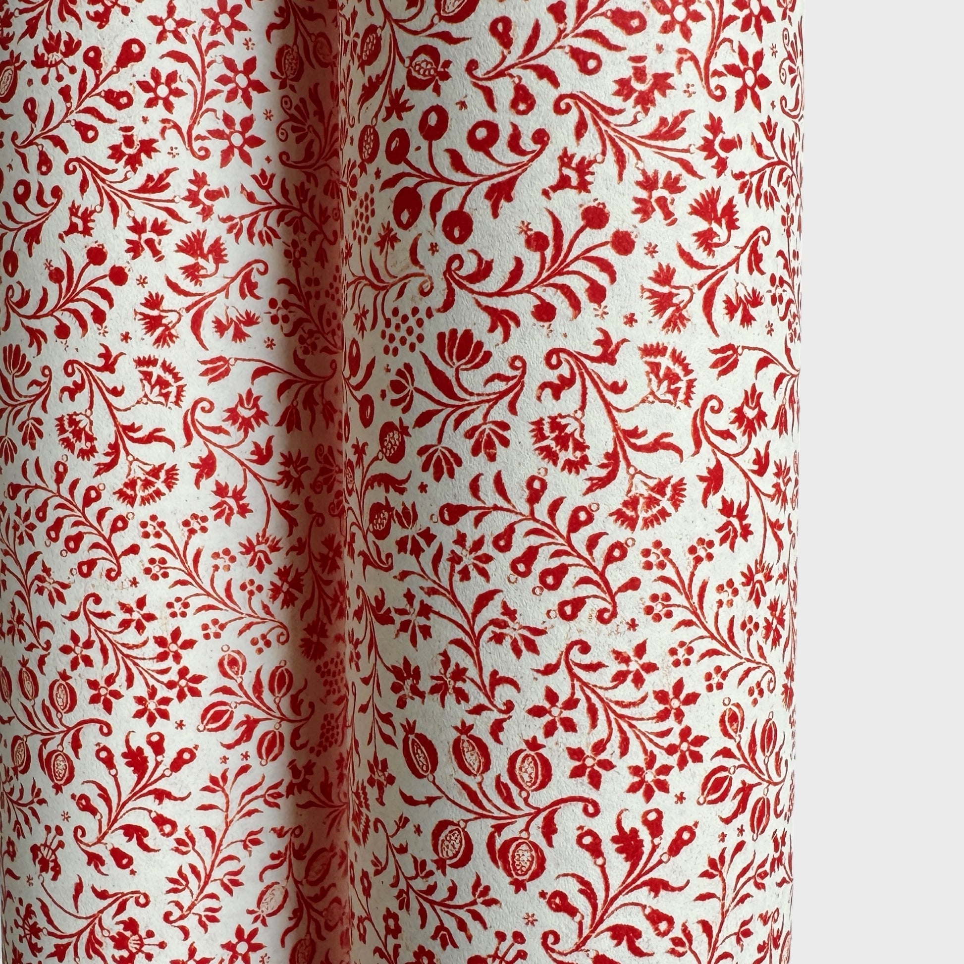 a sheet of italian wrapping paper with a small delicate floral pattern in red on white background