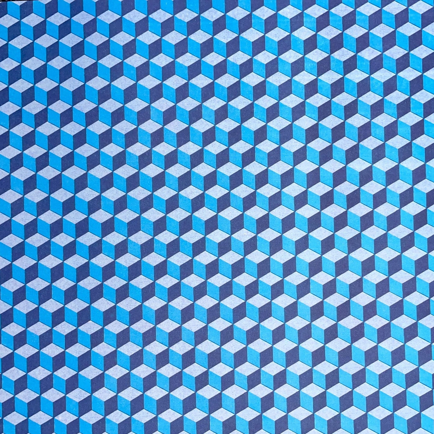 Italian patterned wrapping paper "Carta Varese" by Grafiche Tassotti.  A pattern of blue, aqua a navy geometric cubes with a 3D effect